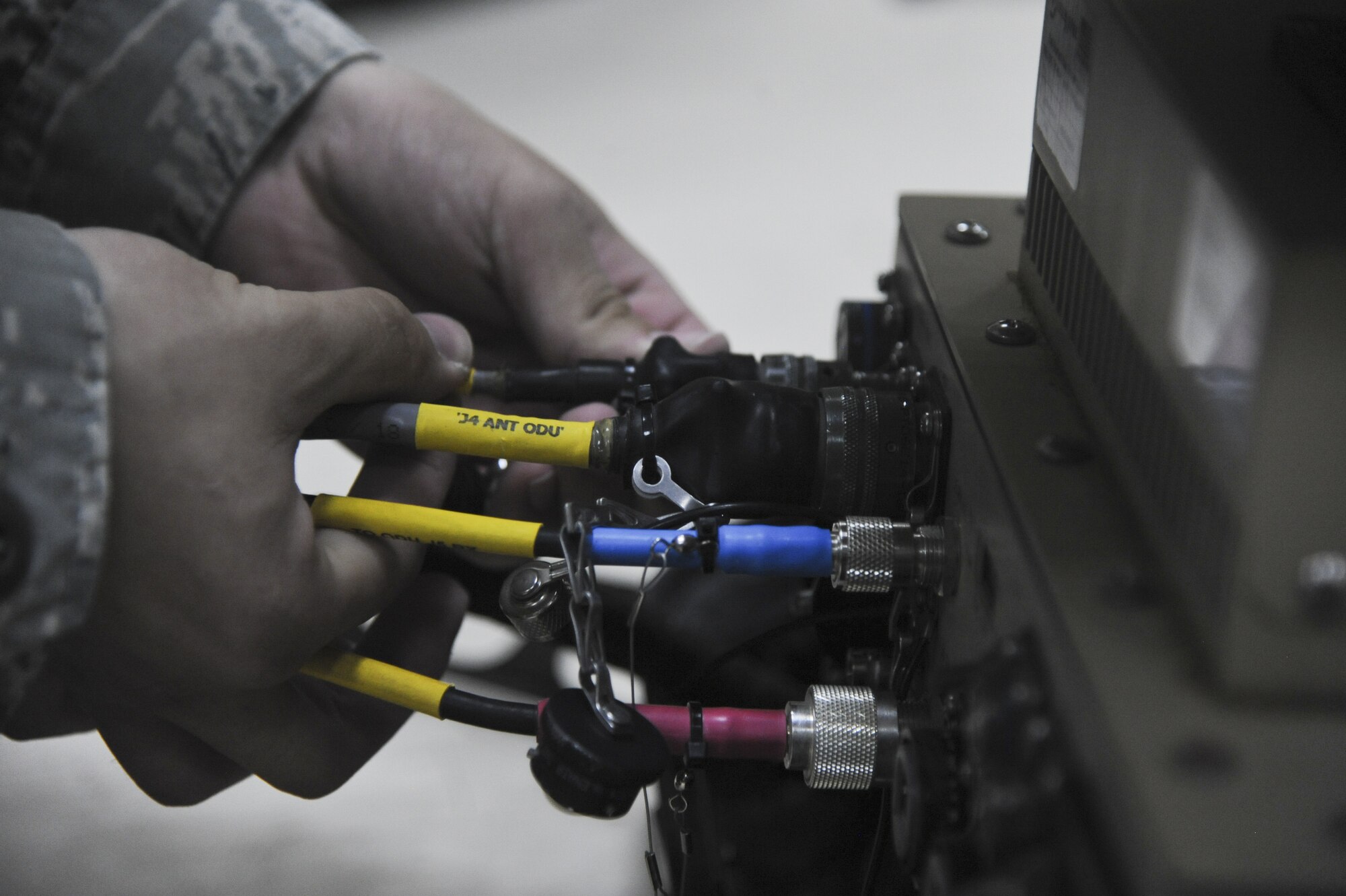 U.S. Air Force Airman 1st Class Steven Hamm, 380th Expeditionary Communications Squadron radio frequency journeyman, connects the antenna path to the data controller, which allows him to manipulate the antenna dishes direction and software settings at an undisclosed location in Southwest Asia July 23, 2013. The radio frequency shop maintains all equipment and proccesses using radio frequency to communicate, which encompasses more than 3,000 pieces of equipment and several different jobs. Hamm is from Aurora, Colo., and is deployed from Kapaun Air Station, Germany. (U.S. Air Force photo by Senior Airman Jacob Morgan)