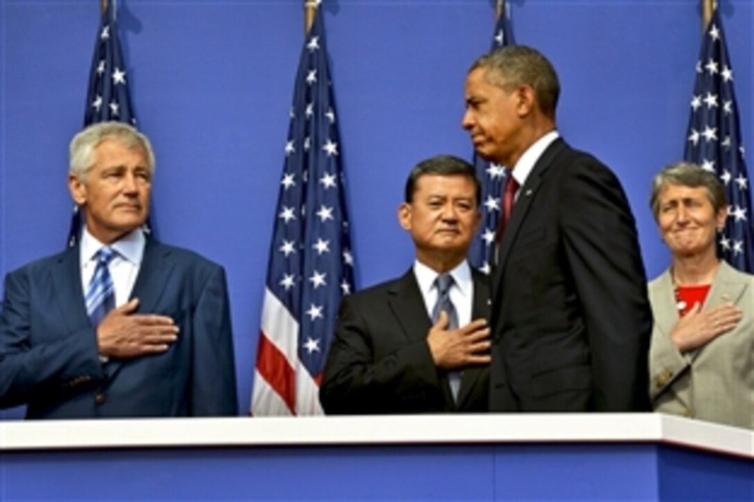 President Barack Obama walks onto a stage at the Korean War Memorial in Washington, D.C., July 27, 2013, as Defense Secretary Chuck Hagel, left, and Veterans Affairs Secretary Eric K. Shinseki look on as they mark the 60th anniversary of the armistice ending the Korean War.