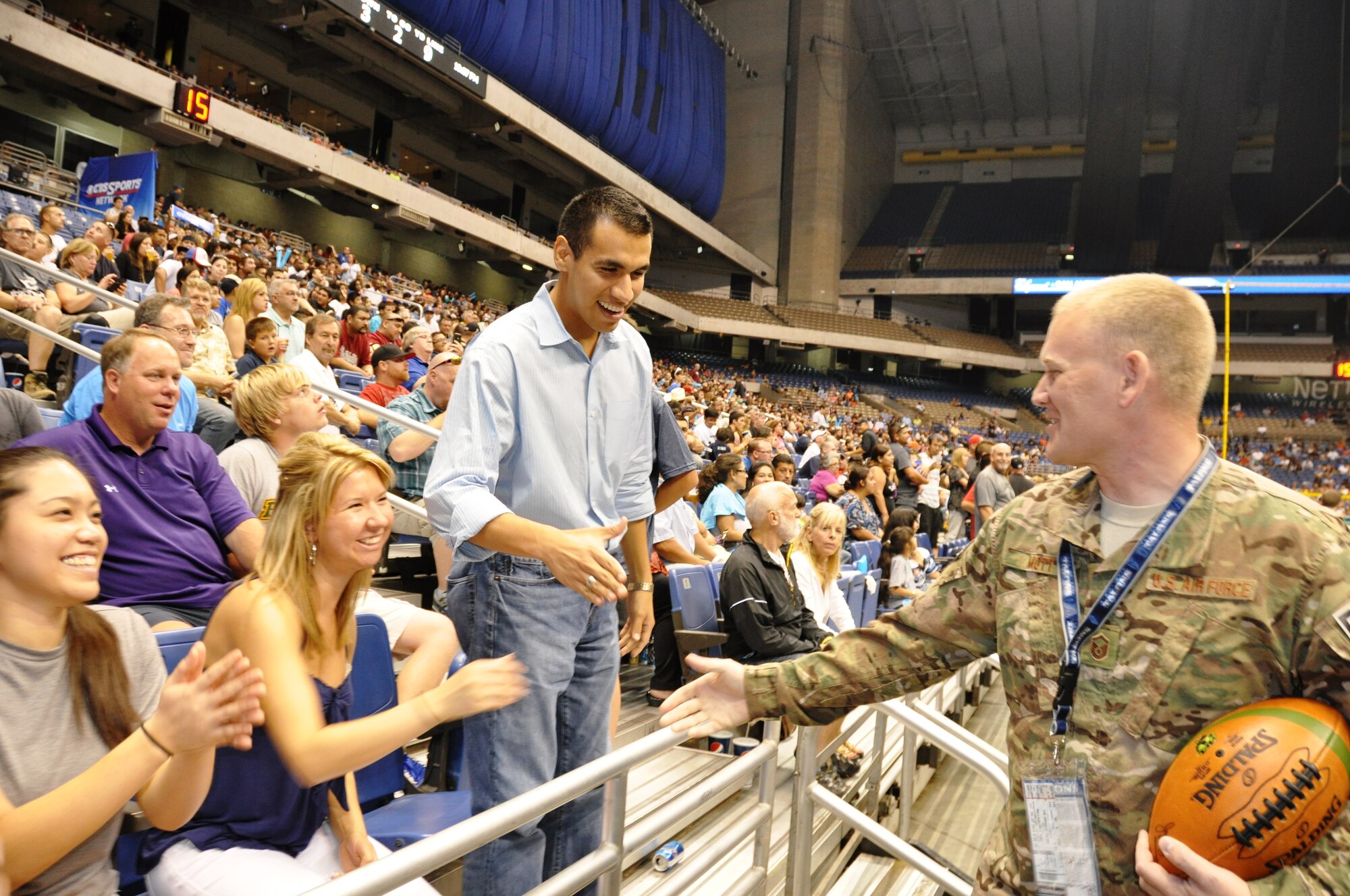 After a ceremony honoring him, Master Sgt. Robert Mott, 433rd EOD Flight Program Manager, meets and greets some of the 9,112 in attendance at the Alamodome for an Arena Football Game on July 27 between the San Antonio Talons and the Philadelphia Soul. Mott received a standing ovation and a game ball during the ceremony at the game in recognition of his receiving the Bronze Star for his actions in Fallujah, Iraq.  (Photo by Tech Sgt. Carlos J. Trevino)