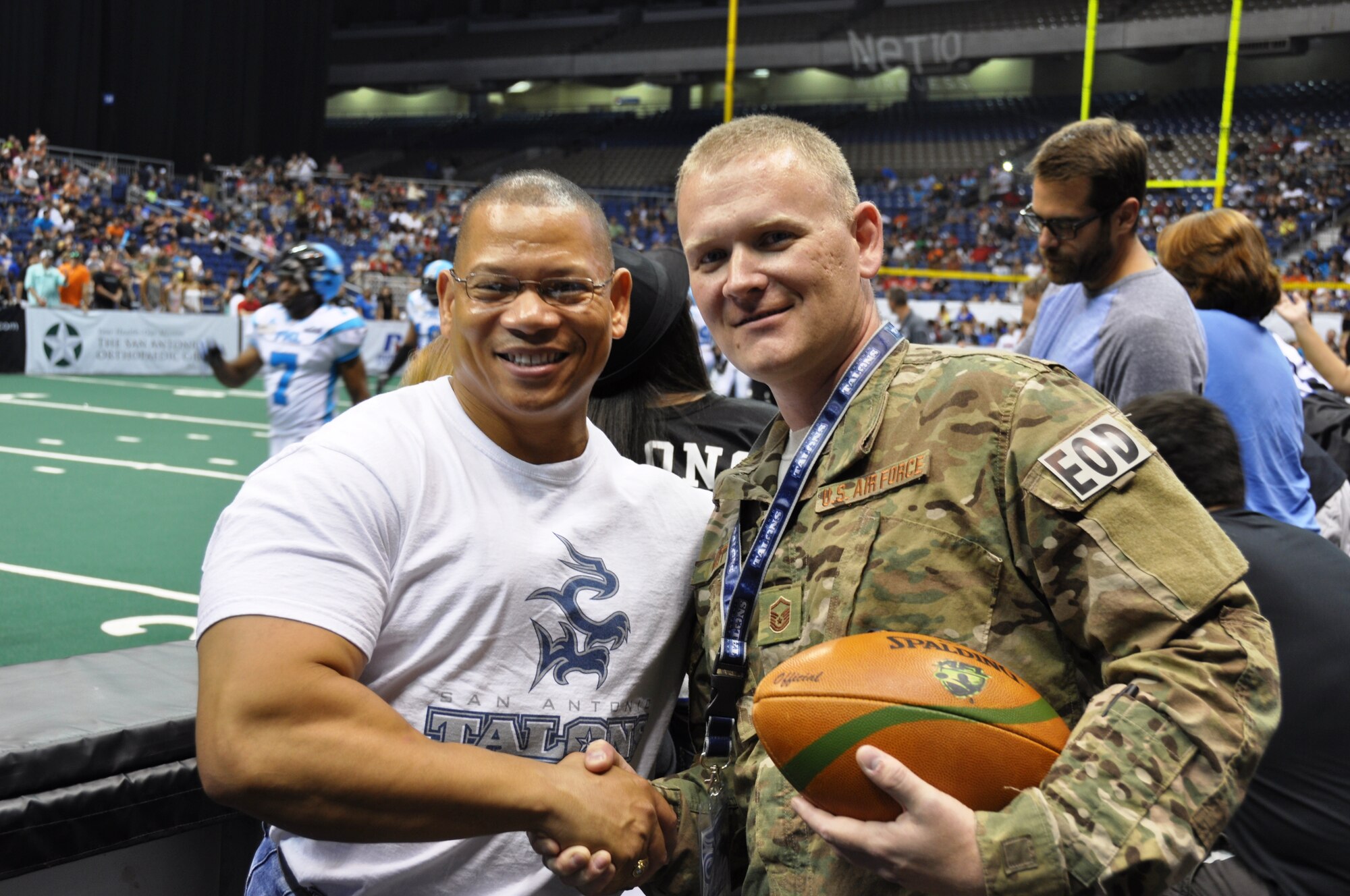 After a ceremony honoring him, Master Sgt. Robert Mott, 433rd EOD Flight Program Manager, meets and greets some of the 9,112 in attendance at the Alamodome for an Arena Football Game on July 27 between the San Antonio Talons and the Philadelphia Soul. Maj. Oliver George , Mott's former commander, congratulates Mott after the ceremony. (Photo by Tech Sgt. Carlos J. Trevino)