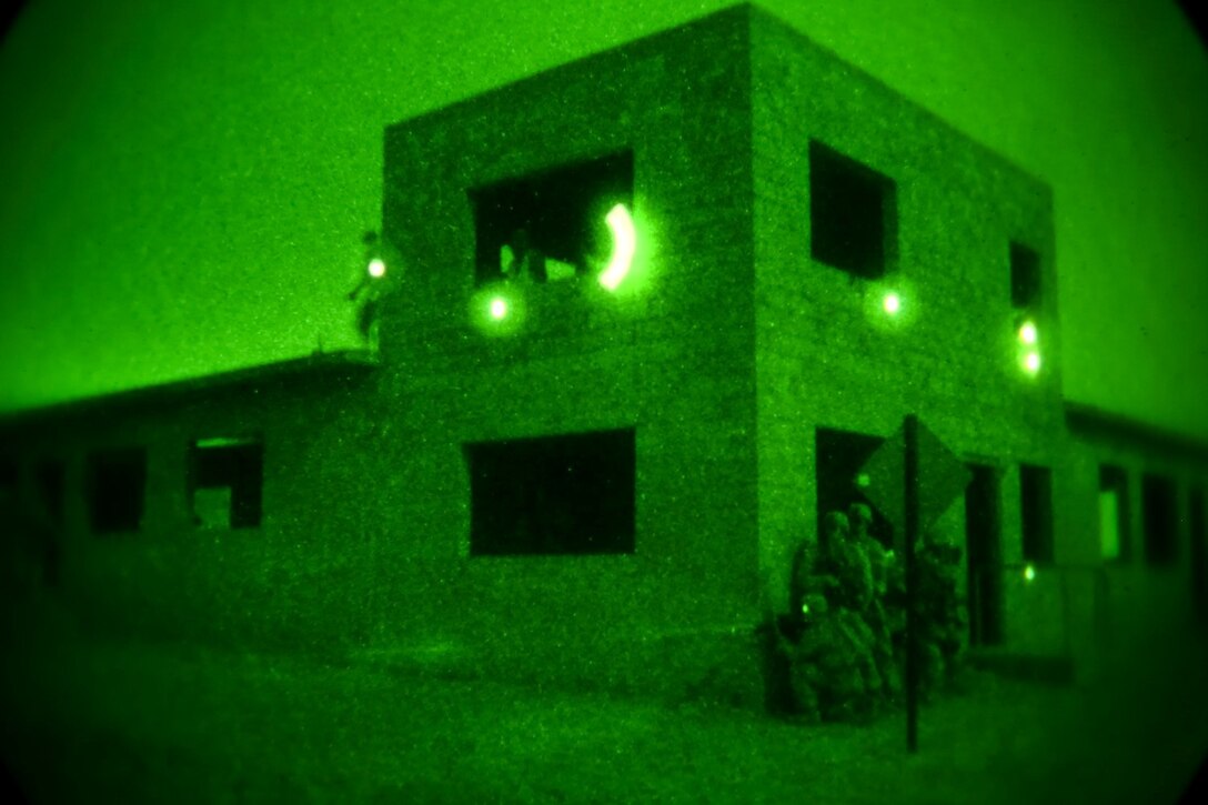 Marines and sailors of Echo Company, 2nd Battalion, 5th Marine Regiment, assault a notional enemy objective during a mechanized night raid at Combat Town 25 here, July 18, 2013. Echo Co. trained with 3rd Assault Amphibian Bn., and Special Operations and Training Group for the raid, to prepare the unit for an upcoming deployment with the 31st Marine Expeditionary Unit later this year. The raid prepared the Marines for actions against an unconventional force, which utilizes a prepared defense.