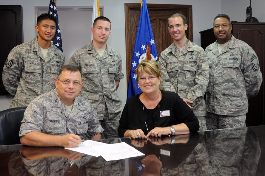 U.S. Air Force Col. John Griffin, 35th Mission Support Group commander, signs an internet memorandum agreement alongside Shirley Huth, Misawa Exchange general manager, at Misawa Air Base, Japan, July 17, 2013. The memorandum agreement is between the 35th Fighter Wing and the Army and Air Force Exchange Service and authorized the installation of faster commercial internet services to base residents. (U.S. Air Force photo/Staff Sgt. April Quintanilla)
