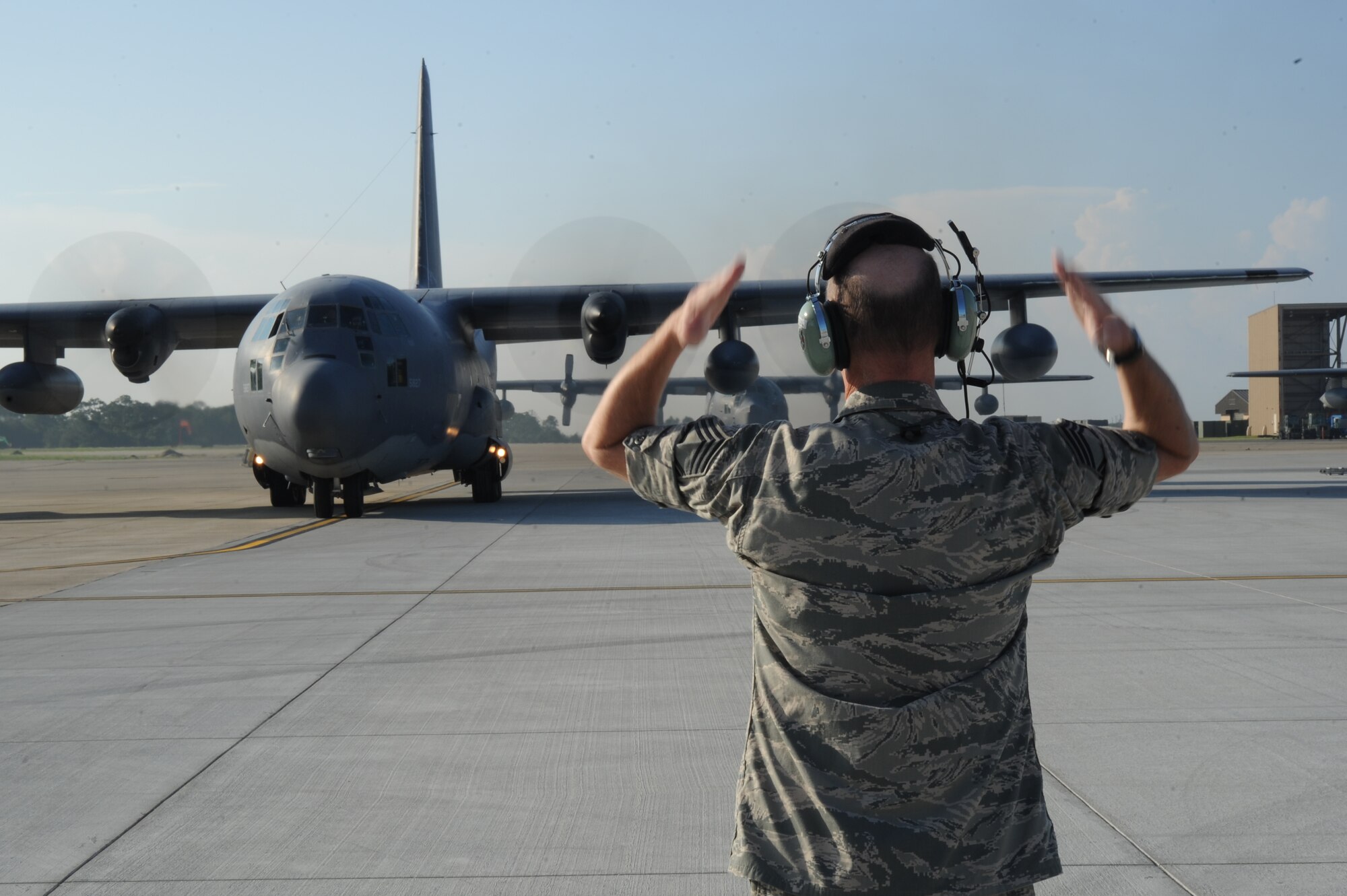 Chief Master Sgt. Scott Doremus, maintenance superintendent of the 1st Special Operations Aircraft Maintenance Squadron, marshals out a MC-130P Combat Shadow for the last time at Hurlburt Field, Fla., July 29, 2013. Doremus worked on this aircraft throughout his Air Force career for the past 28 years. (U.S. Air Force staff Eboni Reams)