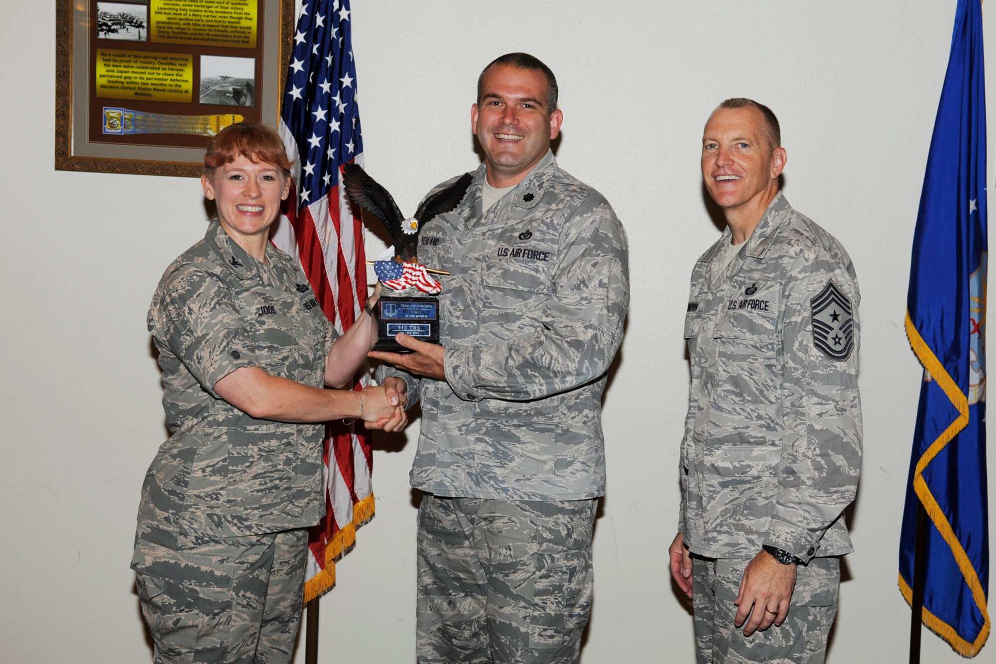 GOODFELLOW AIR FORCE BASE, Texas -- Col. Kimberlee Joos, 17th Training Wing Commander, and Chief Master Sgt. Scott Lumpkin, 17th TRW Command Chief, present the 17th Training Wing Team GAFB Unit of the Quarter to the 312th Training Squadron during the wing quarterly awards ceremony, July 25. (U.S. Air Force photo by Staff Sgt. Austin Knox)