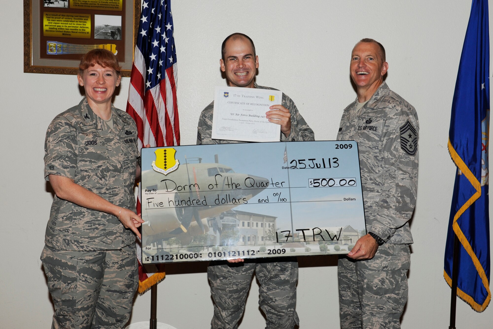 GOODFELLOW AIR FORCE BASE, Texas -- Col. Kimberlee Joos, 17th Training Wing Commander, and Chief Master Sgt. Scott Lumpkin, 17th TRW Command Chief, present the 17th Training Wing Team GAFB Permanent Party Dormitory of the Quarter to B243, Air Force, during the wing quarterly awards ceremony, July 25. (U.S. Air Force photo by Staff Sgt. Austin Knox)