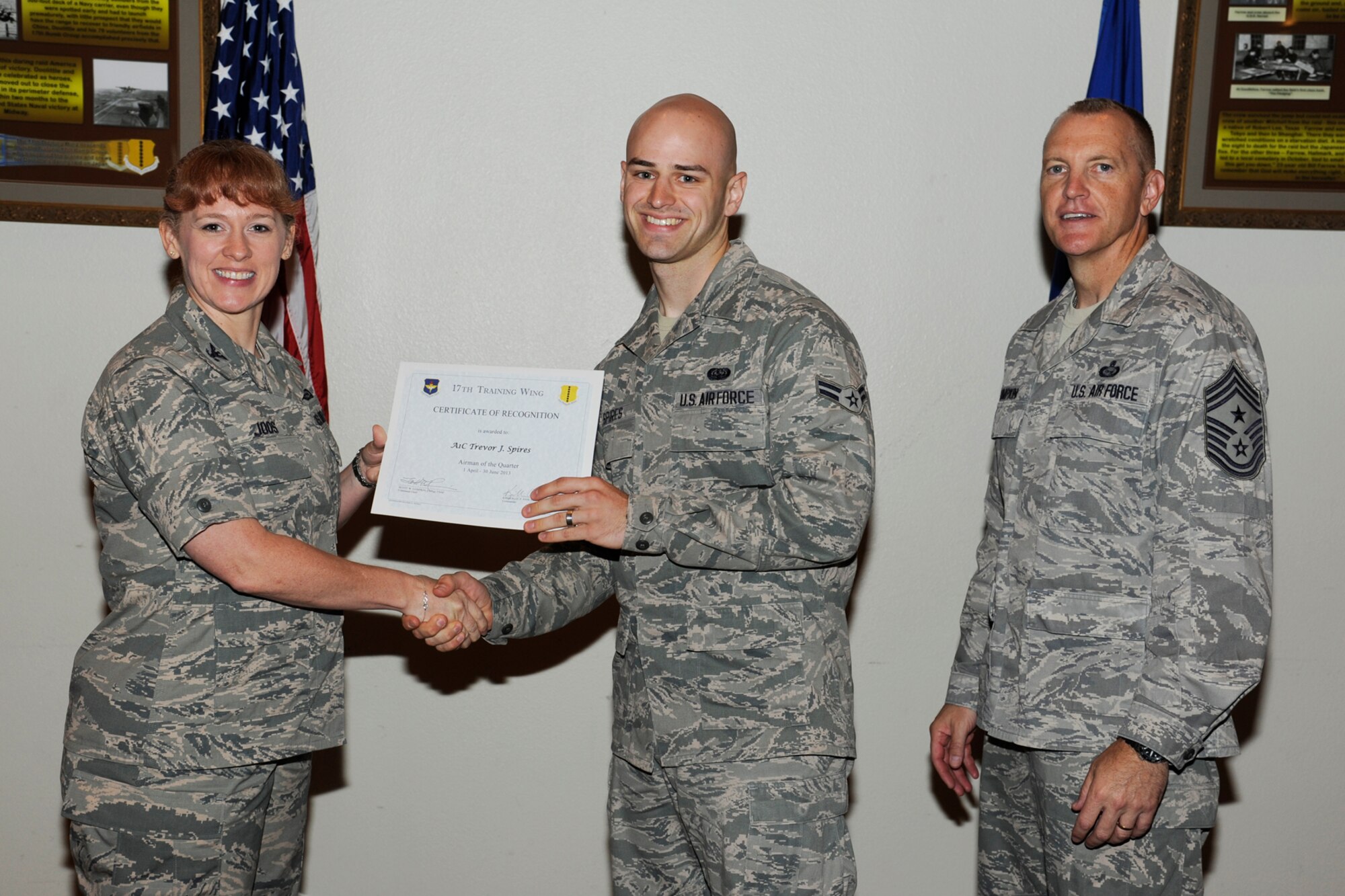GOODFELLOW AIR FORCE BASE, Texas -- Col. Kimberlee Joos, 17th Training Wing Commander, and Chief Master Sgt. Scott Lumpkin, 17th TRW Command Chief, present the 17th Training Wing Airman of the Quarter to Airman 1st Class Trevor Spires, 17th Mission Support Group, during the wing quarterly awards ceremony, July 25. (U.S. Air Force photo by Staff Sgt. Austin Knox)