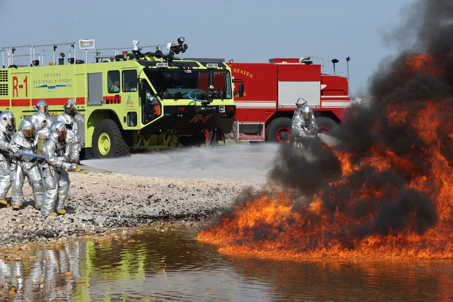 The 7th Civil Engineer Squadron Fire Department and Abilene Regional Airport Fire Department work in conjunction to put out a fire during a training exercise, July 24, 2013, at Dyess Air Force Base, Texas. Dyess works closely with Abilene fire departments and allows them to train on Dyess AFB for certain aircraft rescue scenarios.  (U.S. Air Force photo by Airman 1st Class Alexander Guerrero/Released)