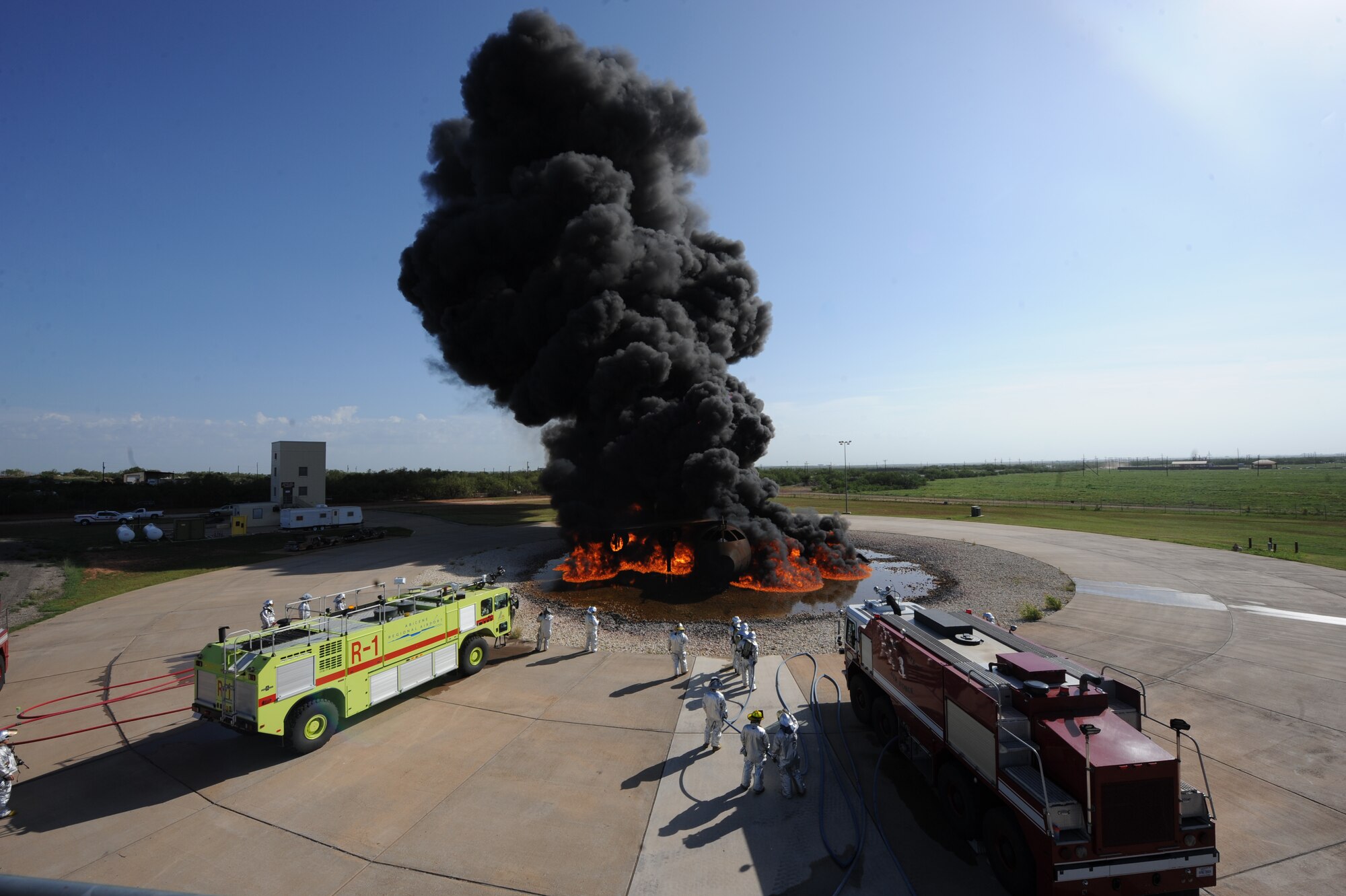 The 7th Civil Engineer Squadron Fire Department and Abilene Regional Airport Fire Department prepare to extinguish a jet fuel fire during a training exercise, July 24, 2013, at Dyess Air Force Base, Texas. The Dyess Fire Department works with several local fire departments to help keep them qualified on quarterly and annual training. (U.S. Air Force photo by Airman 1st Class Alexander Guerrero/Released)