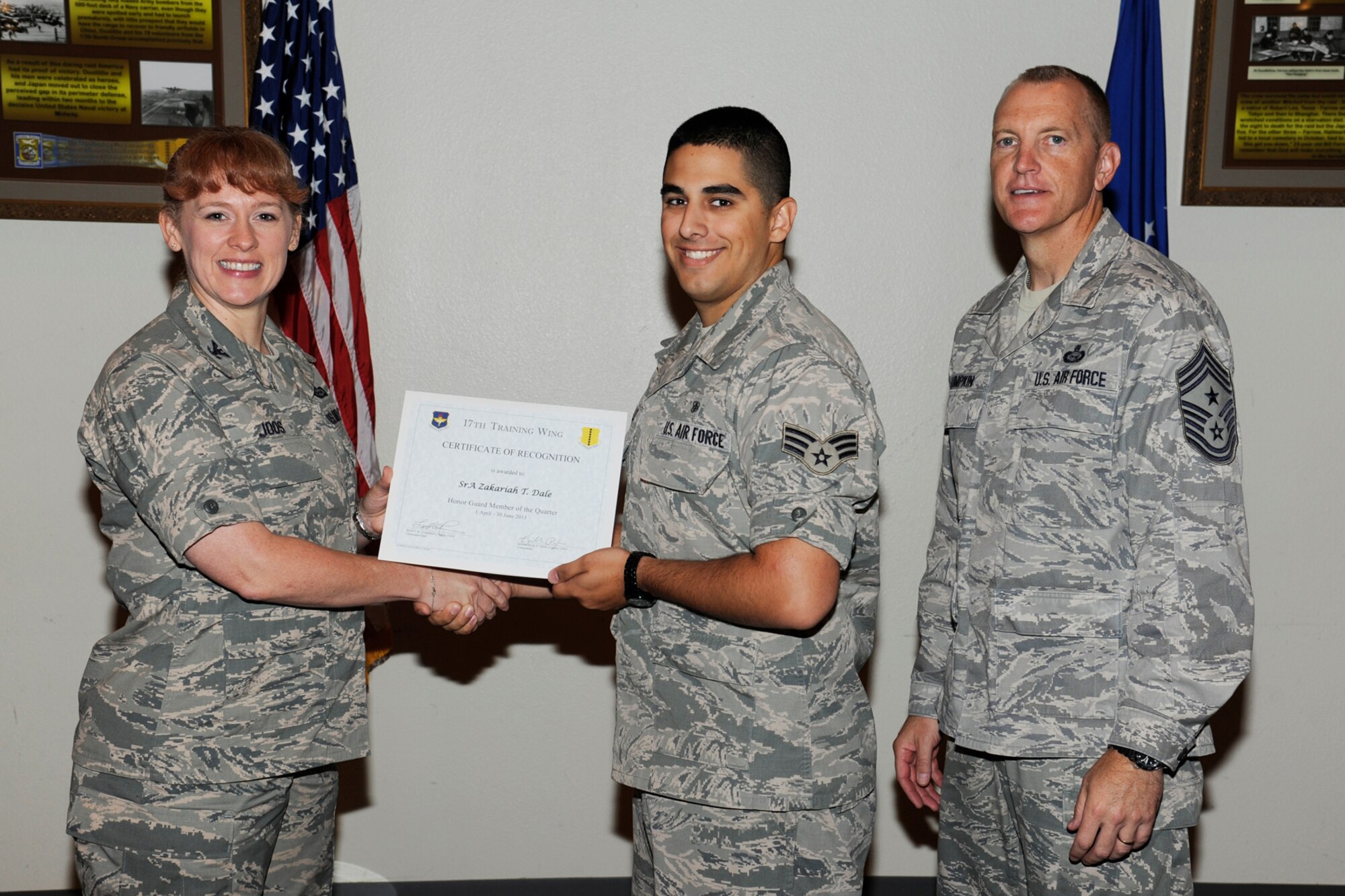 GOODFELLOW AIR FORCE BASE, Texas -- Col. Kimberlee Joos, 17th Training Wing Commander, and Chief Master Sgt. Scott Lumpkin, 17th TRW Command Chief, present the 17th Training Wing Honor Guard Member of the Quarter to Senior Airman Zakariah Dale, 17th Medical Group, during the wing quarterly awards ceremony, July 25. (U.S. Air Force photo by Staff Sgt. Austin Knox)