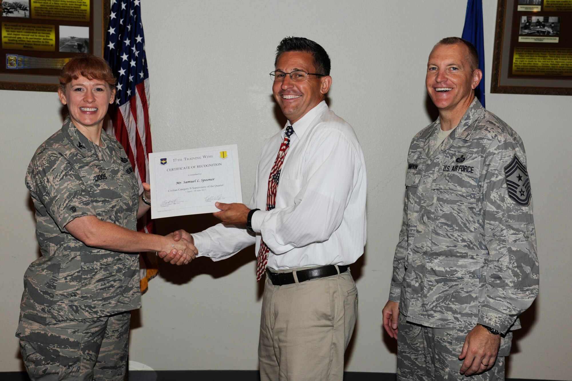 GOODFELLOW AIR FORCE BASE, Texas -- Col. Kimberlee Joos, 17th Training Wing Commander, and Chief Master Sgt. Scott Lumpkin, 17th TRW Command Chief, present the 17th Training Wing Civilian of the Quarter, Supervisory Category II, to Samuel Spooner III, 17th TRW, during the wing quarterly awards ceremony, July 25. (U.S. Air Force photo by Staff Sgt. Austin Knox)