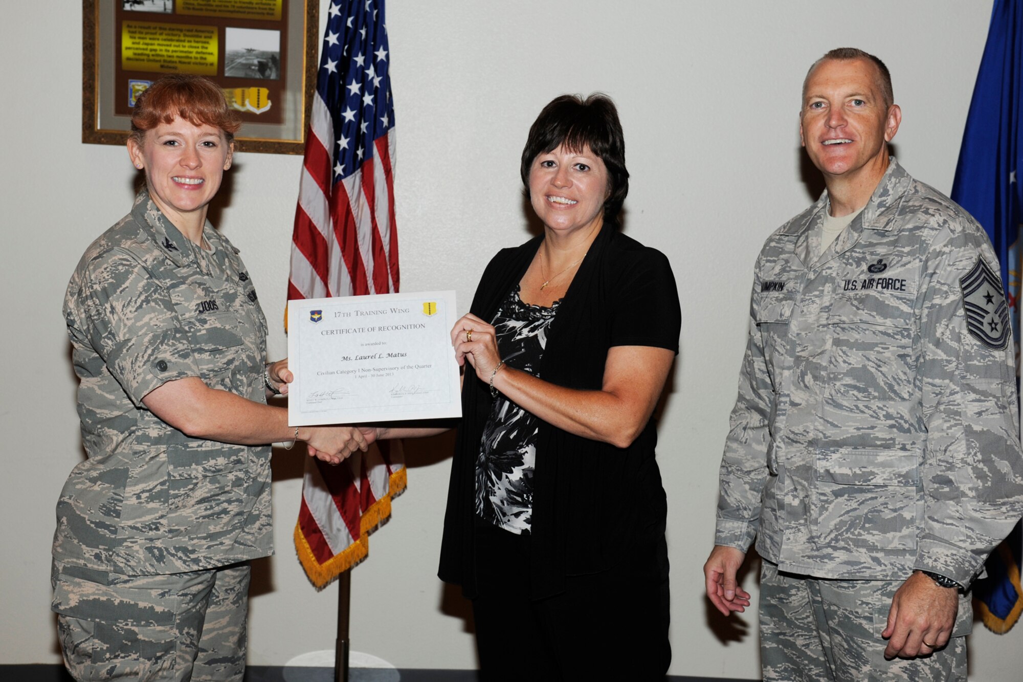 GOODFELLOW AIR FORCE BASE, Texas -- Col. Kimberlee Joos, 17th Training Wing Commander, and Chief Master Sgt. Scott Lumpkin, 17th TRW Command Chief, present the 17th Training Wing Civilian of the Quarter, Non-Supervisory, Category I to Laurel Matus, 17th TRW, during the wing quarterly awards ceremony, July 25. (U.S. Air Force photo by Staff Sgt. Austin Knox)