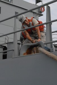 A Soldier from the 805th Transportation Detachment prepares to dock the Maj. Gen. Robert Smalls, a Logistics Support Vessel, at Fort Eustis, Va., July 24, 2013.  Thirty-one Soldiers returned aboard the Smalls, ending their 10-month deployment to the Persian Gulf in support of Operating Enduring Freedom. (U.S. Army photo by Sgt. Marc Loi/Released)