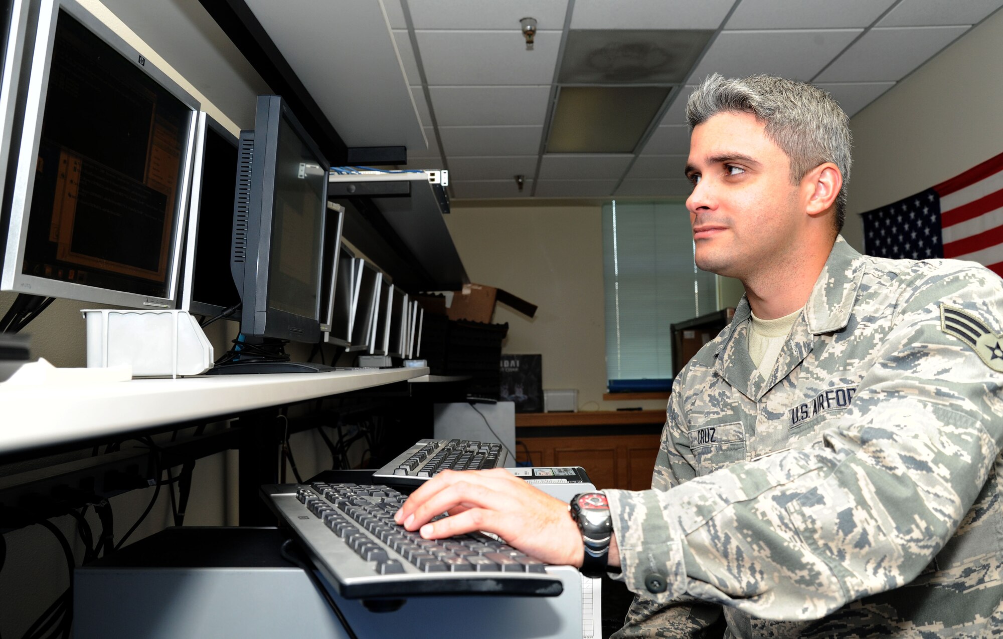 Senior Airman Jose Cruz, 92nd Communications Squadron client system technician, runs security patches on a computer at Fairchild Air Force Base, Wash., July 29, 2013. Cruz has been selected as Fairchild’s Finest. (U.S. Air Force photo by Airman 1st Class Janelle Patiño/Released)
