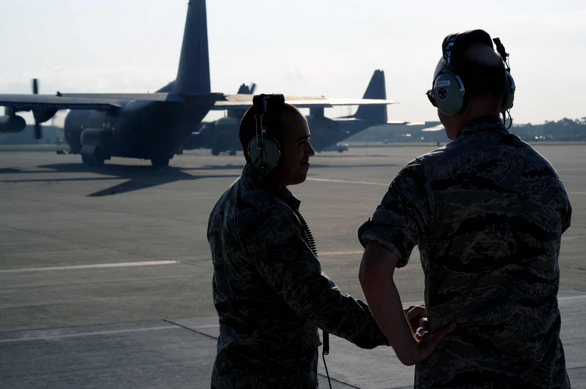 Staff Sgt. Jason De La Mora, dedicated crew chief of the 1st Special Operations Maintenance Squadron, shakes hands with Chief Master Sgt. Scott Doremus as a MC-130P Combat Shadow taxis to the runway at Hurlburt Field, Fla., July 29, 2013. De La Mora and Doremus both worked on the Combat Shadow. (U.S. Air Force photo/Staff Sgt. Eboni Reams)