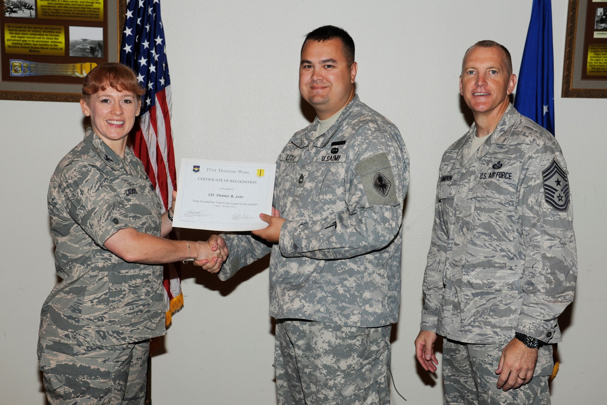 GOODFELLOW AIR FORCE BASE, Texas -- Col. Kimberlee Joos, 17th Training Wing Commander, and Chief Master Sgt. Scott Lumpkin, 17th TRW Command Chief, present the 17th Training Wing Team GAFB Joint Color Guard of the Quarter to Sergeant 1st Class Dennis Leto, 344th Military Intelligence Battalion, during the wing quarterly awards ceremony, July 25. (U.S. Air Force photo by Staff Sgt. Austin Knox)