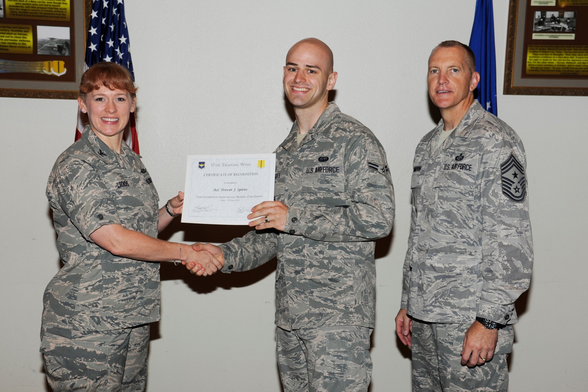 GOODFELLOW AIR FORCE BASE, Texas -- Col. Kimberlee Joos, 17th Training Wing Commander, and Chief Master Sgt. Scott Lumpkin, 17th TRW Command Chief, present the 17th Training Wing Team GAFB Junior Service Member of the Quarter to Airman 1st Class Trevor Spires, 17th Mission Support Group, during the wing quarterly awards ceremony, July 25. (U.S. Air Force photo by Staff Sgt. Austin Knox)