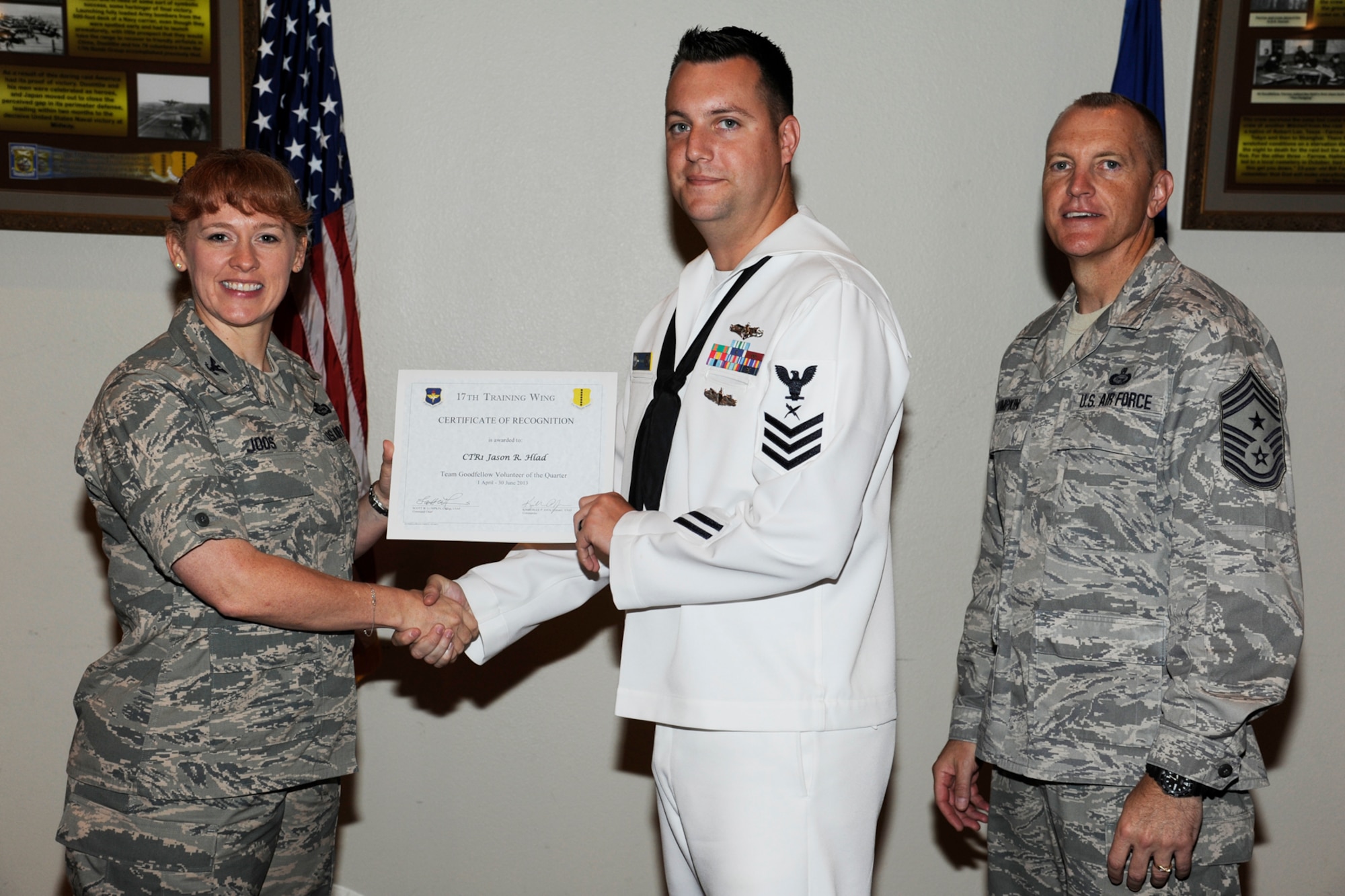 GOODFELLOW AIR FORCE BASE, Texas -- Col. Kimberlee Joos, 17th Training Wing Commander, and Chief Master Sgt. Scott Lumpkin, 17th TRW Command Chief, present the 17th Training Wing Team GAFB Volunteer of the Quarter to Petty Officer 1st Class Jason Hlad, Navy Center for Information Dominance, during the wing quarterly awards ceremony, July 25. (U.S. Air Force photo by Staff Sgt. Austin Knox)