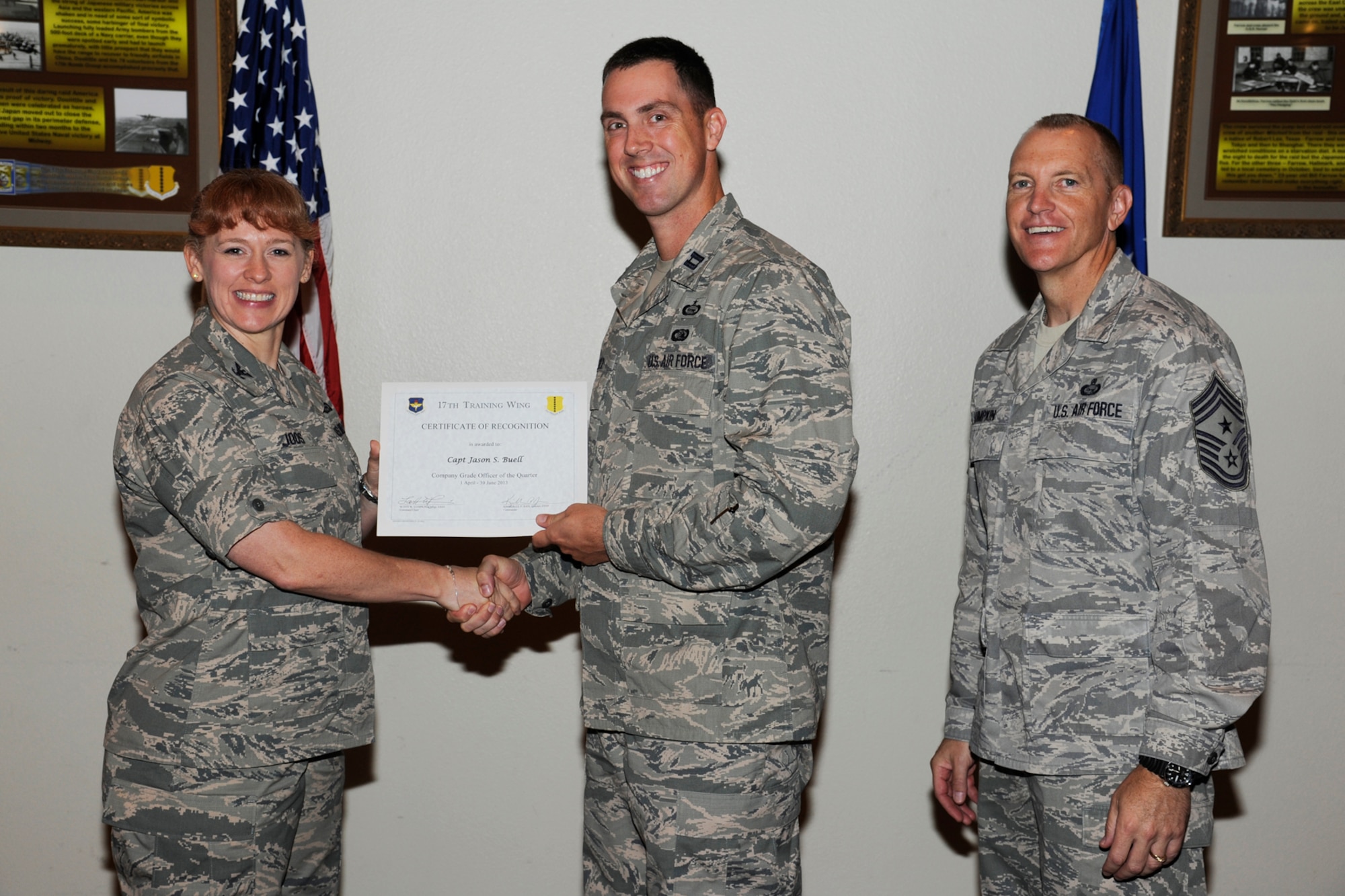 GOODFELLOW AIR FORCE BASE, Texas -- Col. Kimberlee Joos, 17th Training Wing Commander, and Chief Master Sgt. Scott Lumpkin, 17th TRW Command Chief, present the 17th Training Wing CGO of the Quarter to Capt. Jason Buell, 17th Training Group, during the wing quarterly awards ceremony, July 25. (U.S. Air Force photo by Staff Sgt. Austin Knox)