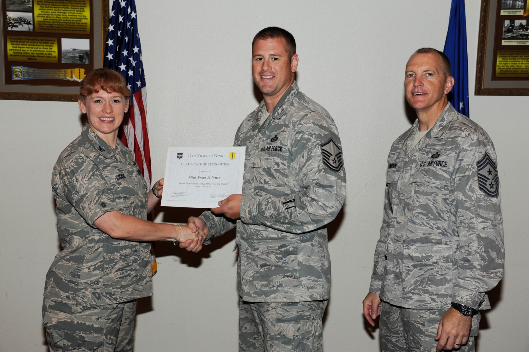 GOODFELLOW AIR FORCE BASE, Texas -- Col. Kimberlee Joos, 17th Training Wing Commander, and Chief Master Sgt. Scott Lumpkin, 17th TRW Command Chief, present the 17th Training Wing SNCO of the Quarter to Master Sgt. Brian Witte, 17th Training Group, during the wing quarterly awards ceremony, July 25. (U.S. Air Force photo by Staff Sgt. Austin Knox)