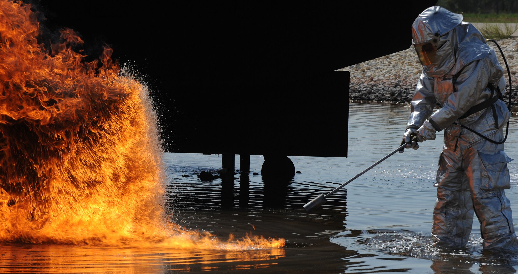 A U.S. Air Force firefighter from the 7th Civil Engineer Squadron points to where a controlled training fire will soon be started, July 24, 2013, at Dyess Air Force Base, Texas. The fire department trains quarterly to maintain a high level of readiness and proficiency. (U.S. Air Force photo by Airman 1st Class Alexander Guerrero/Released)