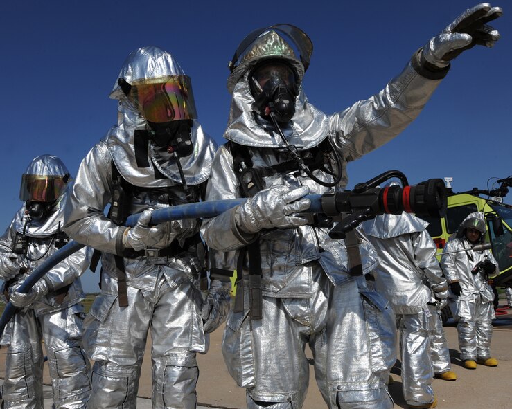 A U.S. Air Force firefighter from the 7th Civil Engineer Squadron points to where a controlled training fire will soon be started, July 24, 2013, at Dyess Air Force Base, Texas. The fire department trains quarterly to maintain a high level of readiness and proficiency. (U.S. Air Force photo by Airman 1st Class Alexander Guerrero/Released)
