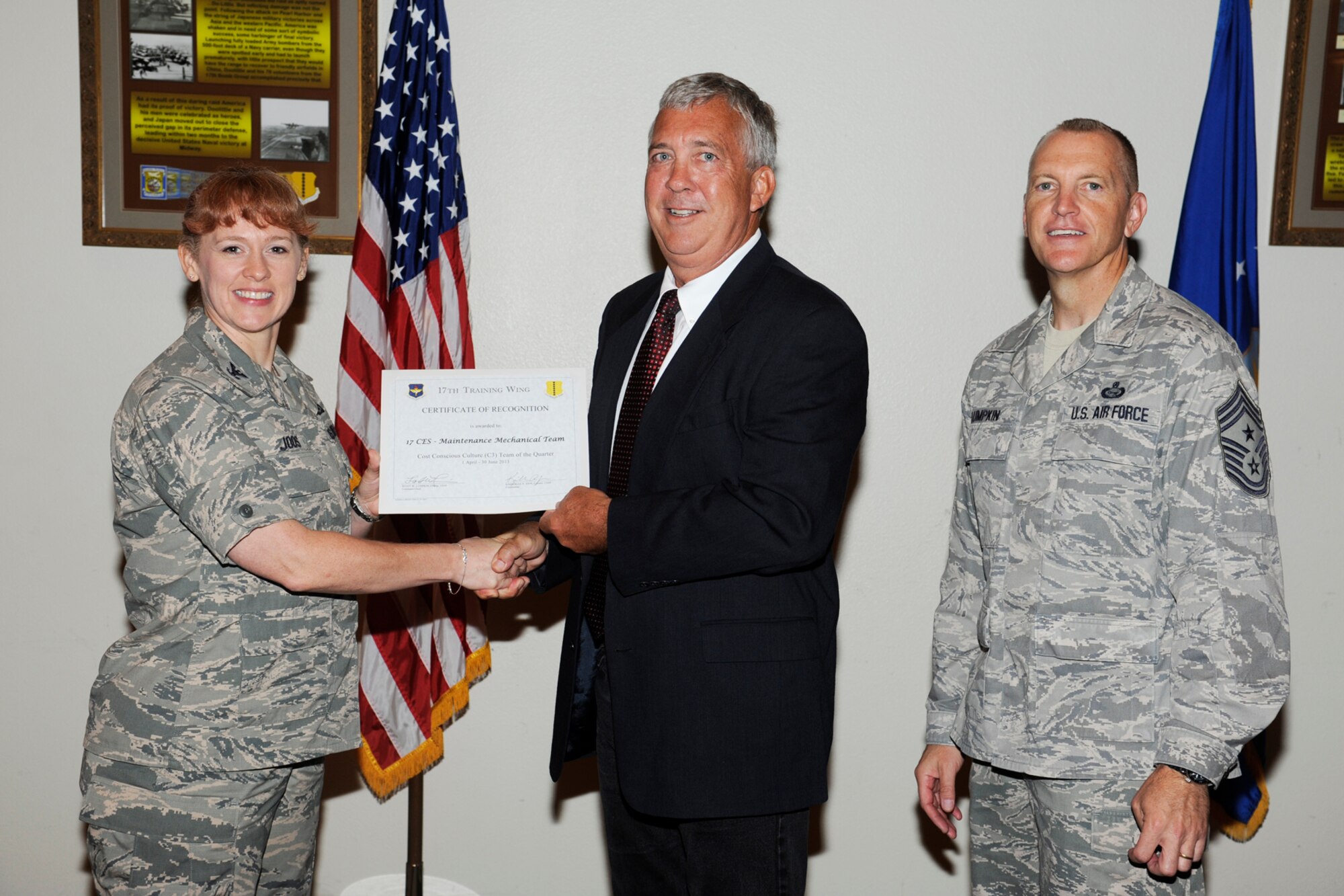 GOODFELLOW AIR FORCE BASE, Texas -- Col. Kimberlee Joos, 17th Training Wing Commander, and Chief Master Sgt. Scott Lumpkin, 17th TRW Command Chief, present the 17th Training Wing C3 Team of the Quarter to 17th Civil Engineer Squadron, Maintenance Mechanical Team, 17th Mission Support Group, during the wing quarterly awards ceremony, July 25. (U.S. Air Force photo by Staff Sgt. Austin Knox)