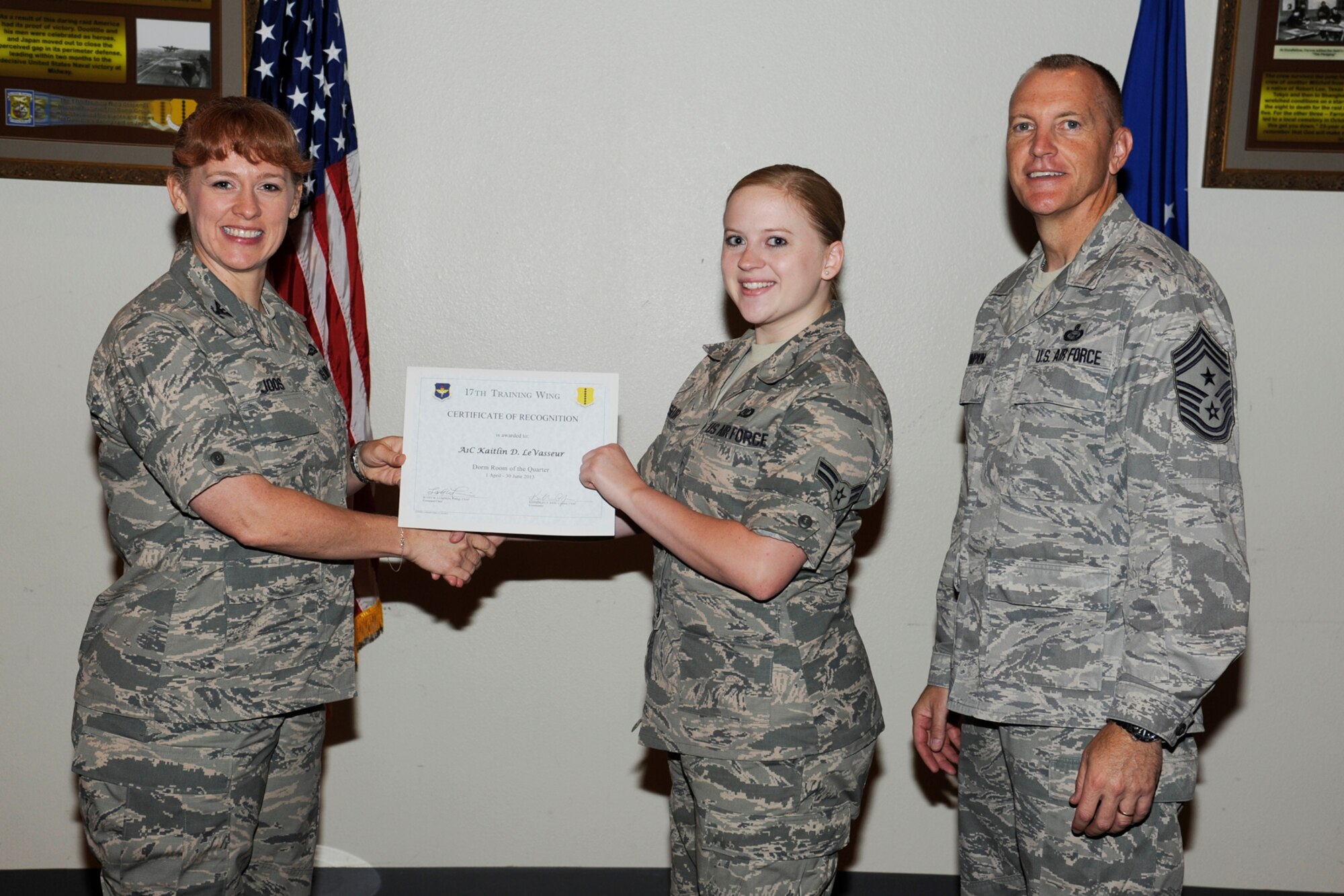 GOODFELLOW AIR FORCE BASE, Texas -- Col. Kimberlee Joos, 17th Training Wing Commander, and Chief Master Sgt. Scott Lumpkin, 17th TRW Command Chief, present the 17th Training Wing Dorm Room of the Quarter to Airman 1st Class Kaitlin LeVasseur, 17th TRW, during the wing quarterly awards ceremony, July 25. (U.S. Air Force photo by Staff Sgt. Austin Knox)