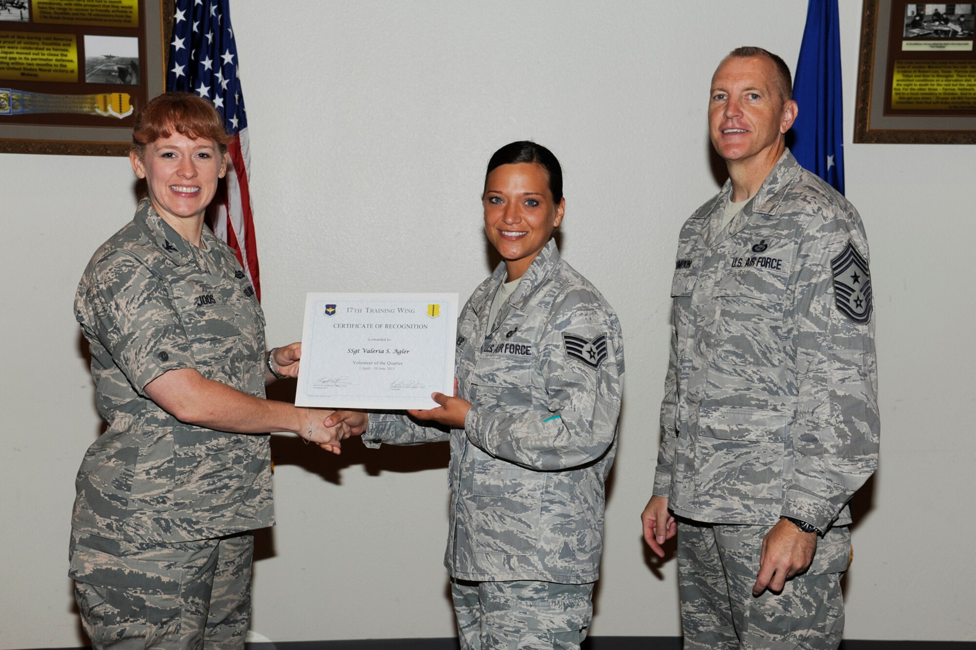 GOODFELLOW AIR FORCE BASE, Texas -- Col. Kimberlee Joos, 17th Training Wing Commander, and Chief Master Sgt. Scott Lumpkin, 17th TRW Command Chief, present the 17th Training Wing Volunteer of the Quarter to Staff Sgt. Valeria Agler, 17th Training Group, during the wing quarterly awards ceremony, July 25. (U.S. Air Force photo by Staff Sgt. Austin Knox)