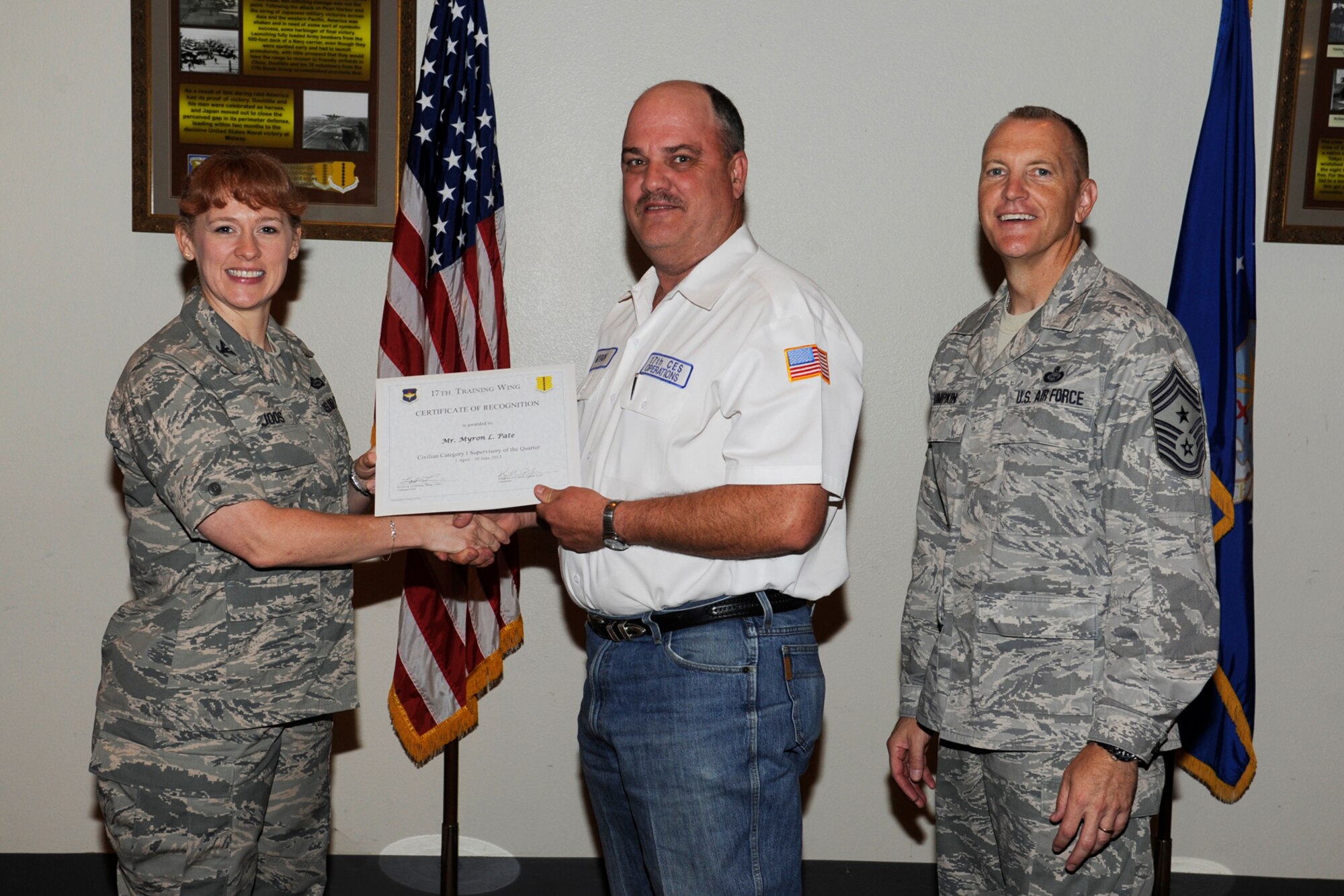 GOODFELLOW AIR FORCE BASE, Texas -- Col. Kimberlee Joos, 17th Training Wing Commander, and Chief Master Sgt. Scott Lumpkin, 17th TRW Command Chief, present the 17th Training Wing Civilian of the Quarter, Supervisory Category I, to Myron Pate, 17th Mission Support Group, during the wing quarterly awards ceremony, July 25. (U.S. Air Force photo by Staff Sgt. Austin Knox)