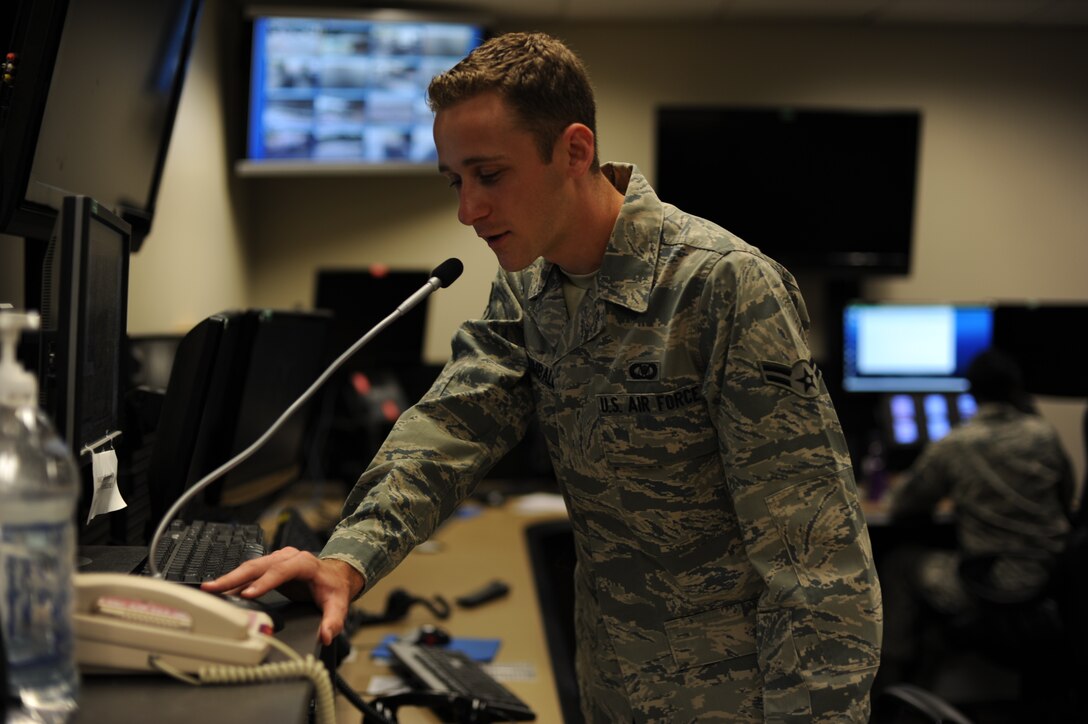 U.S. Air Force Airman 1st Class Timothy Kimball, a junior emergency actions controller with 1st Special Operations Wing Command Post, makes an announcement on the giant voice microphone during an announcement at the 1st SOW Command Post at Hurlburt Field, Fla., July 25, 2013. Kimball, like other 1 SOW/CP personnel, uses the giant voice system to notify the installation populace of flag conditions, weather advisories and potential crisis warnings. (U.S. Air Force Photo / Senior Airman Joe McFadden)