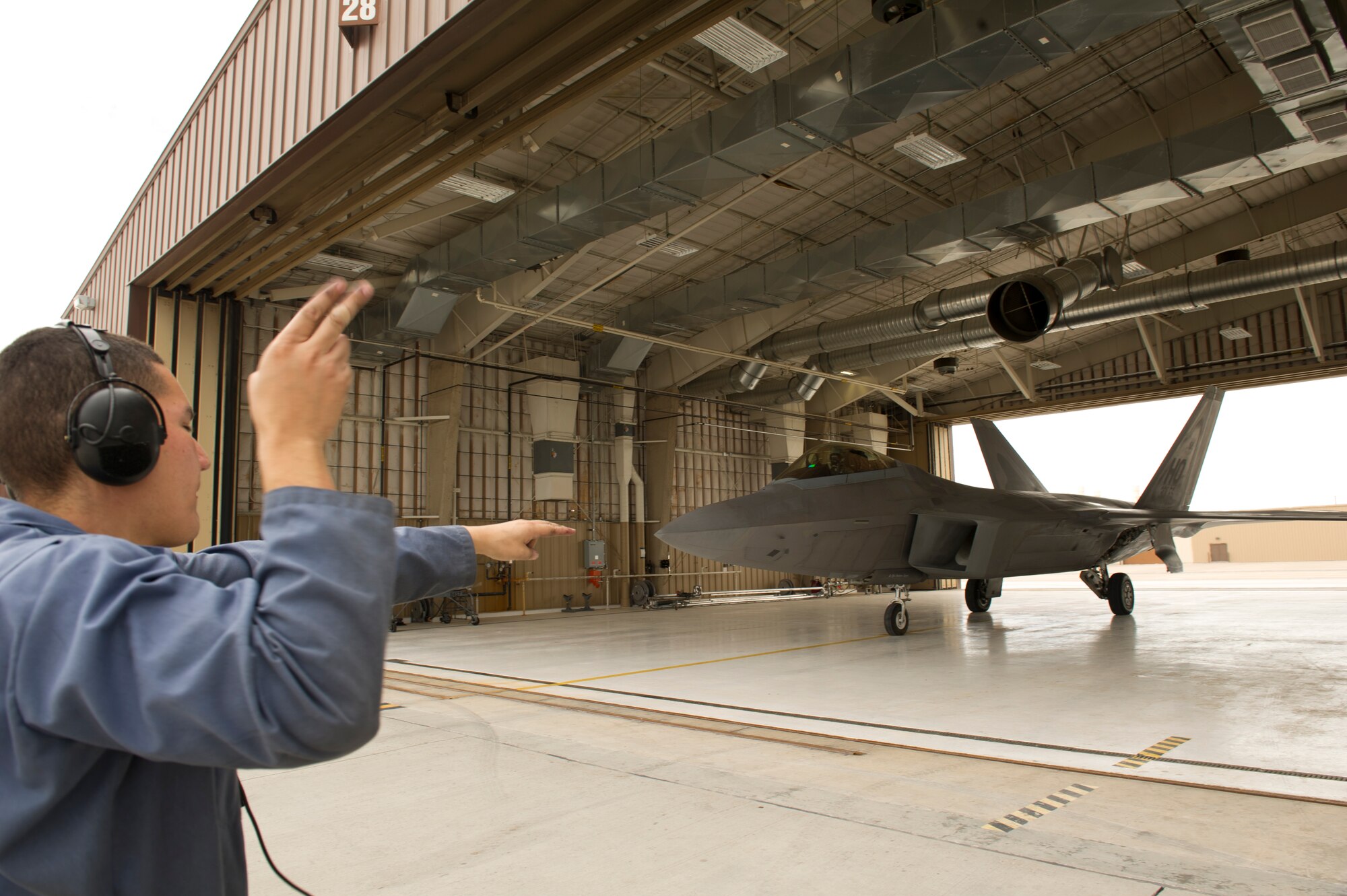 Senior Airman Ricardo Rodriguez, 44th Aircraft Maintenance Squadron F-22 Raptor crew chief, signals 1st Lt. Stephen Renner, 7th Fighter Squadron F-22 pilot, to taxi onto the flightline at Holloman Air Force Base, N.M., July 25. The F-22 has a combination of stealth, supercruise, maneuverability, and integrated avionics, and, when coupled with improved supportability, represents an exponential leap in warfighting capabilities. (U.S. Air Force photo by Senior Airman Kasey Close/Released) 