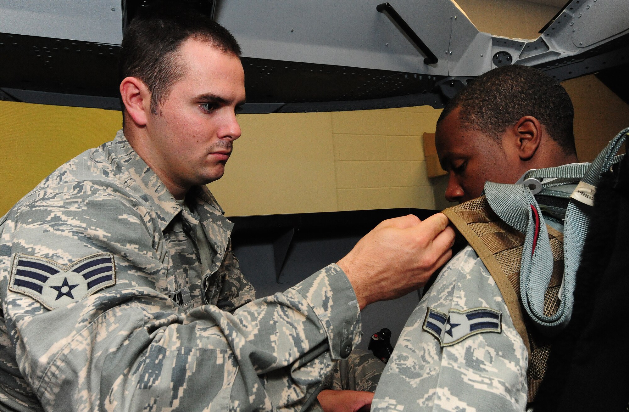 Senior Airman Ethan Mason shows fellow 509th Operations Support Squadron aircrew flight equipment technician Airman 1st Class Dalvin Washington how to attach a night vision device on an Airsave survival vest at Whiteman Air Force Base, Mo., July 16, 2013. This was done as part of a training scenario with the first wave of Airsave technicians, who were equipped to then train other OSS members. (U.S. Air Force photo by Staff Sgt. Nick Wilson/Released)