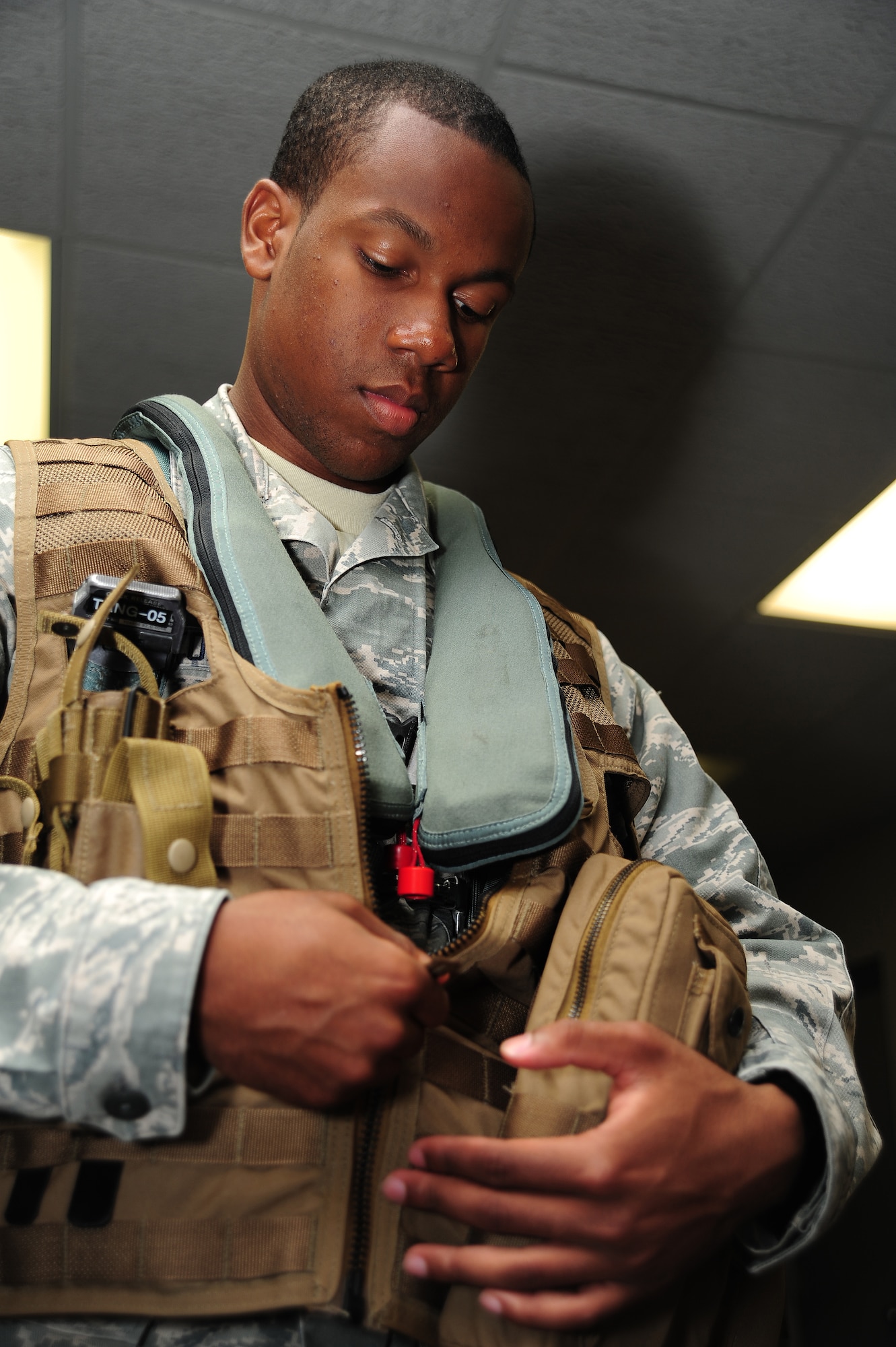 Airman 1st Class Dalvin Washington, 509th Operations Support Squadron aircrew flight equipment apprentice, dons Airsave vest during a training scenario at Whiteman Air Force Base, Mo., July 16, 2013. The vest is made of modular lightweight load-carrying equipment consisting of a basket weave-type strapping system that allows for the addition of various attachments and accessories. (U.S. Air Force photo by Staff Sgt. Nick Wilson/Released)