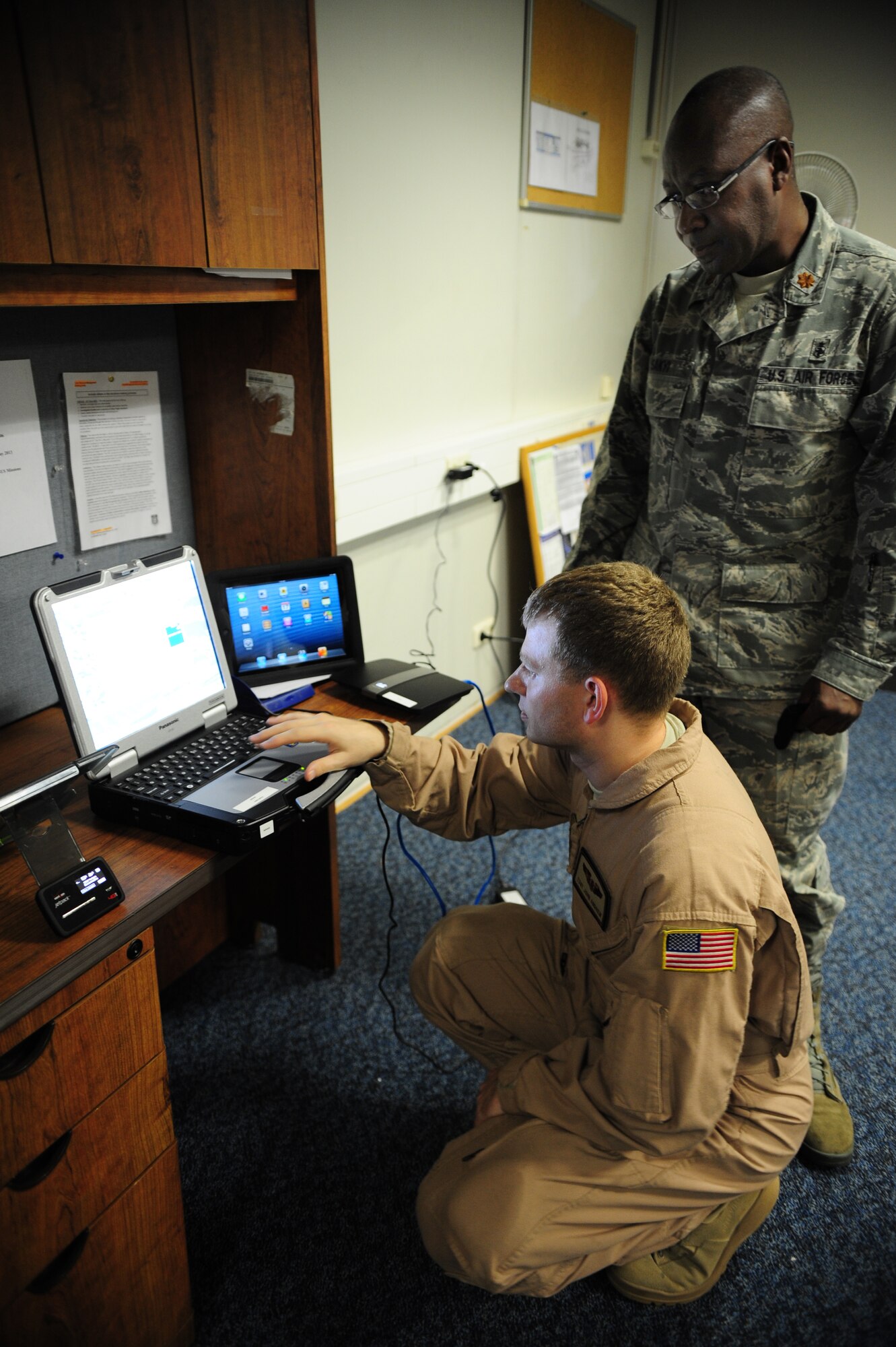 Tech. Sgt. Jonathan Andrew, 375th Aeromedical Evacuation Squadron flight instructor, goes over the electronic health record system and "my Wi-Fi" with Maj. Justice Sakyi, Air Mobility Command division chief, July 17, 2013, Ramstein Air Base, Germany. "My Wi-Fi" is an off-the-shelf device that acts as a hot spot and allows aeromedical evacuation crewmembers to send patient records to that person’s next location before they arrive. (U.S. Air Force photo/Senior Airman Hailey Haux)