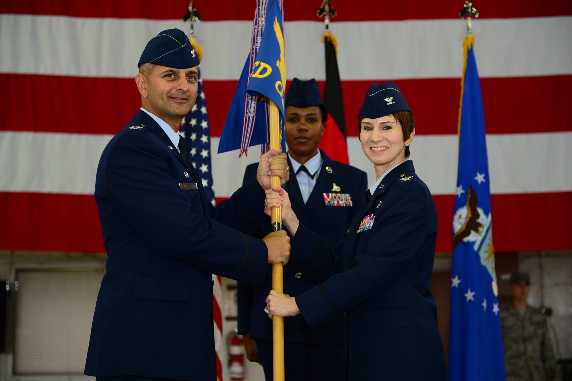 SPANGDAHLEM AIR BASE, Germany – U.S. Air Force Col. David Julazadeh, 52nd Fighter Wing commander, passes the medical group guidon to Col. Jill Scheckel, 52nd Medical Group commander, July 26, 2013. Col. Robert Bowersox relinquished command to Scheckel who assumed command of the 52nd MDG. (U.S. Air Force photo by Airman 1st Class Kyle Gese/Released)