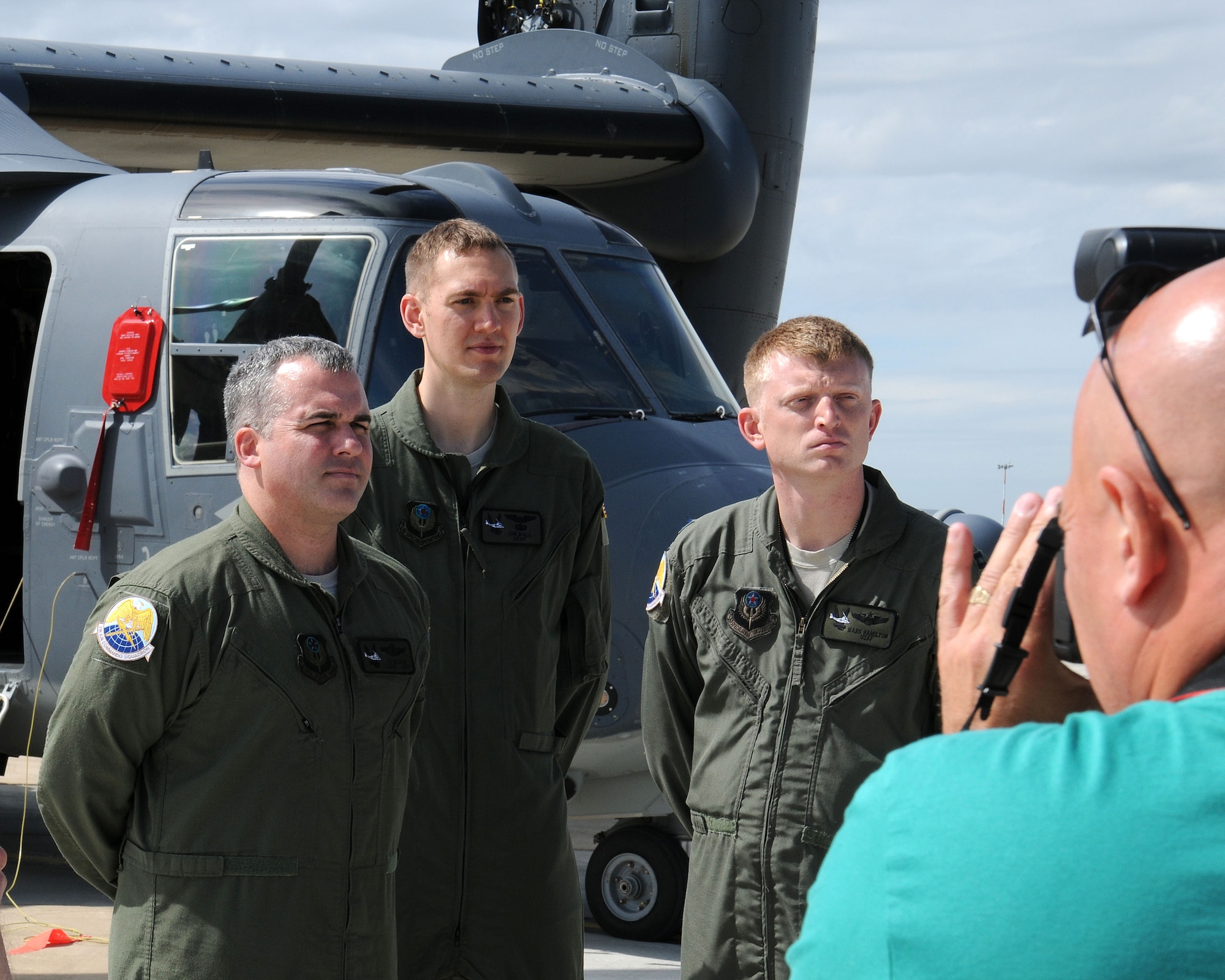 Aircrew members from the 7th Special Operations Squadron pose for photographs from members of the media during a media day event July 26, 2013, on RAF Mildenhall, England. During the event, multiple 352nd Special Operations Group Airmen gave interviews about the unit’s expansion and new aircraft. Participating media and tail spotters were given tours of MC-130J Commando II and CV-22 Osprey aircraft static displays. (U.S. Air Force photo by Gina Randall/Released)