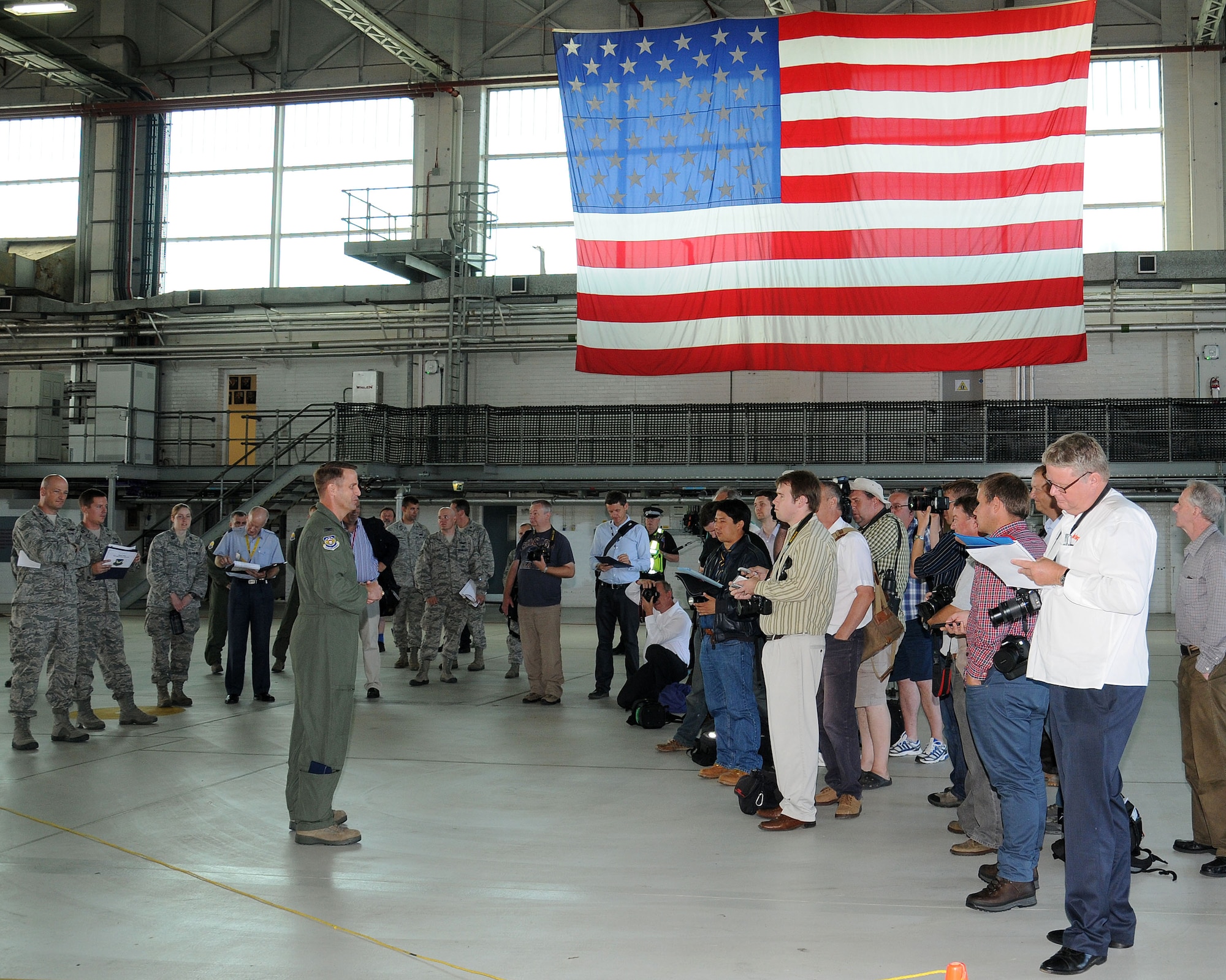 Center, Col. David Cox, 100th Air Refueling Wing vice commander, speaks to members of the media and tail spotter community during a media day event July 26, 2013, in Hangar 539 on RAF Mildenhall, England. During the event, Cox and multiple 352nd Special Operations Group Airmen gave interviews about the unit’s expansion and new aircraft. Participating media and tail spotters were given tours of MC-130J Commando II and CV-22 Osprey aircraft static displays. (U.S. Air Force photo by Gina Randall/Released)