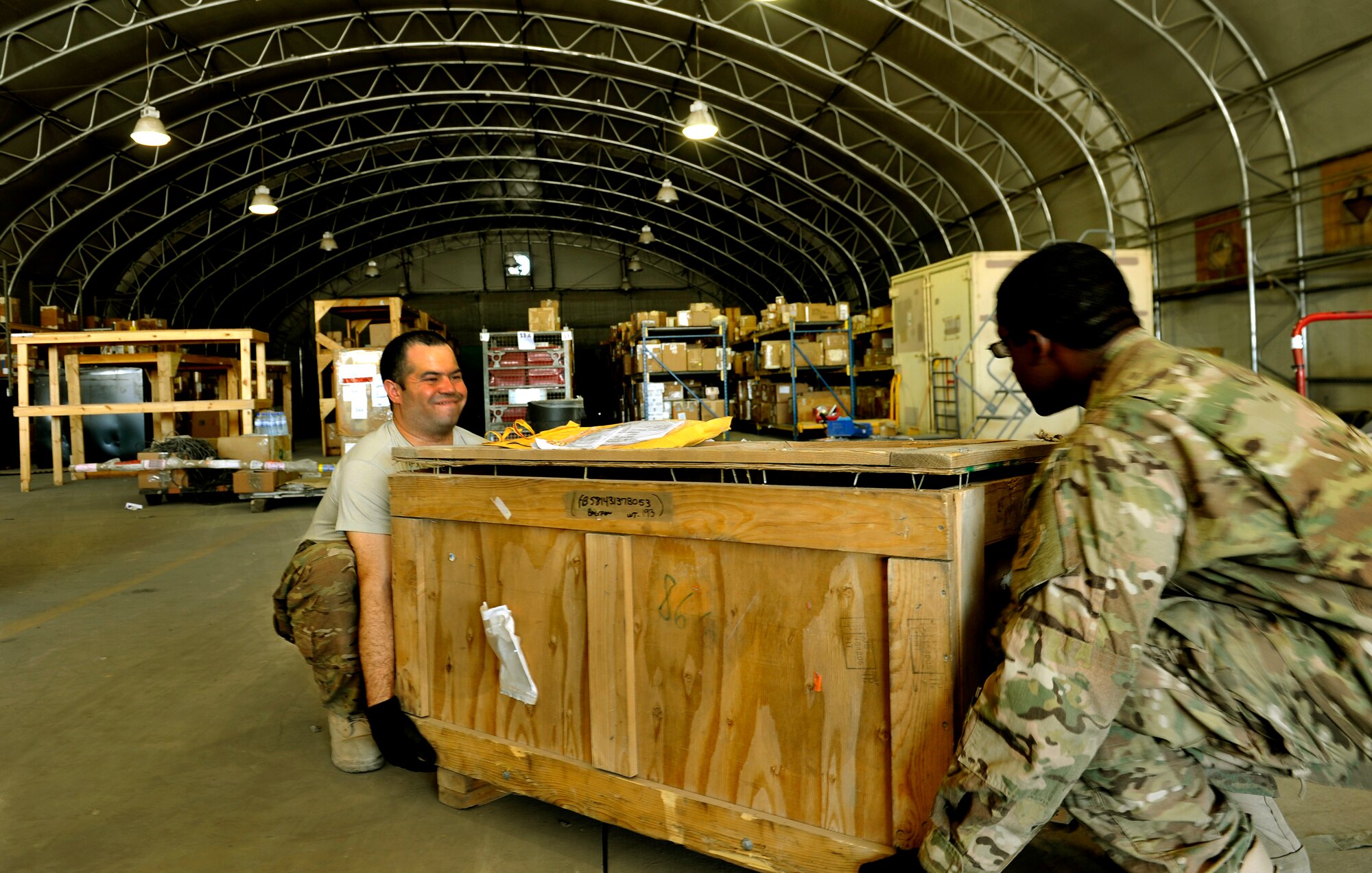 (right to left) Staff Sgt. Jameel Wallace and Senior Airman Tomas Almonte, 455th Expeditionary Logistics Readiness Squadron, C-130 aircraft parts store technicians, carry a new part into their new storage facility on Bagram Airfield, Afghanistan, May 30, 2013. Maintainers rely on members of the aircraft parts store and aircraft flight services centers, to get them the parts they need here on the busiest runway in Afghanistan. Wallace is deployed from Holloman Air Force Base, N.M., and Almonte is deployed from Davis Monthan AFB, Ariz. ( U.S. Air Force photo/ Staff Sgt. Stephenie Wade)