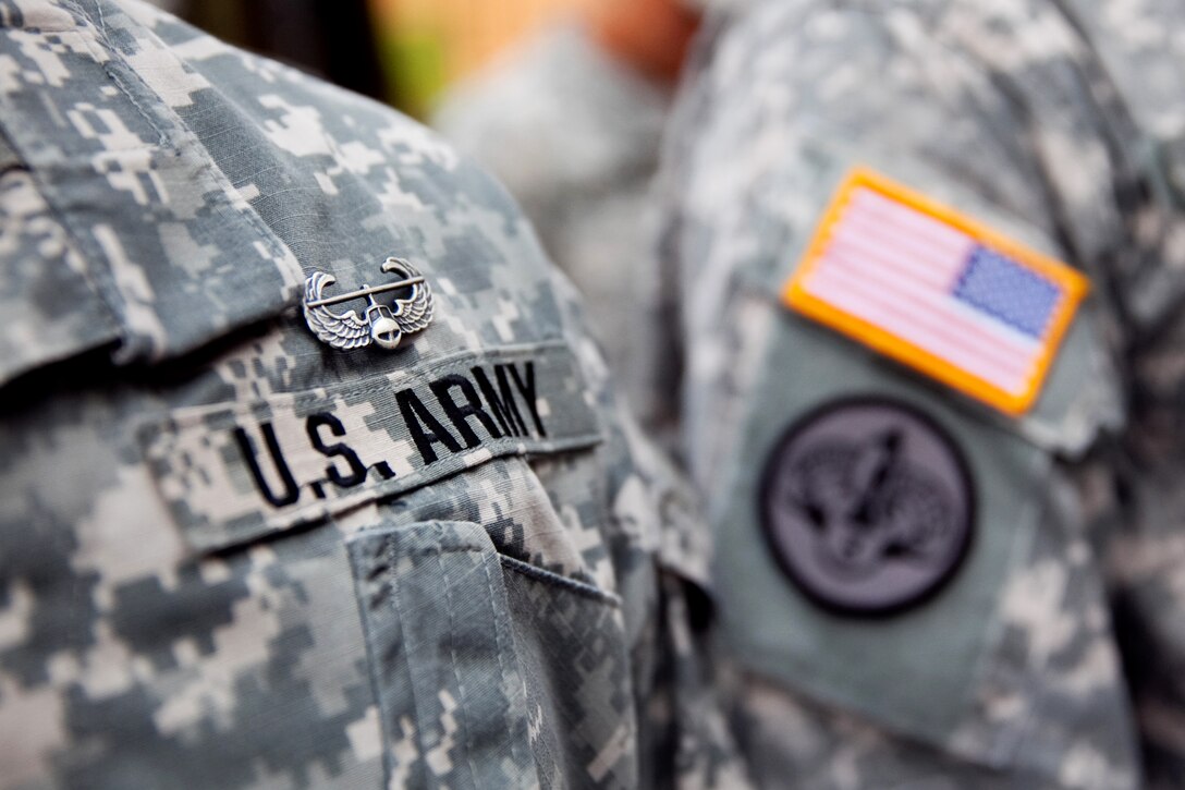 Air assault wings are pinned on Army soldiers and cadets following a final 12-mile foot march and graduation ceremony at the Army National Guard Warrior Training Center on Fort Benning, Ga., July 24, 2013.