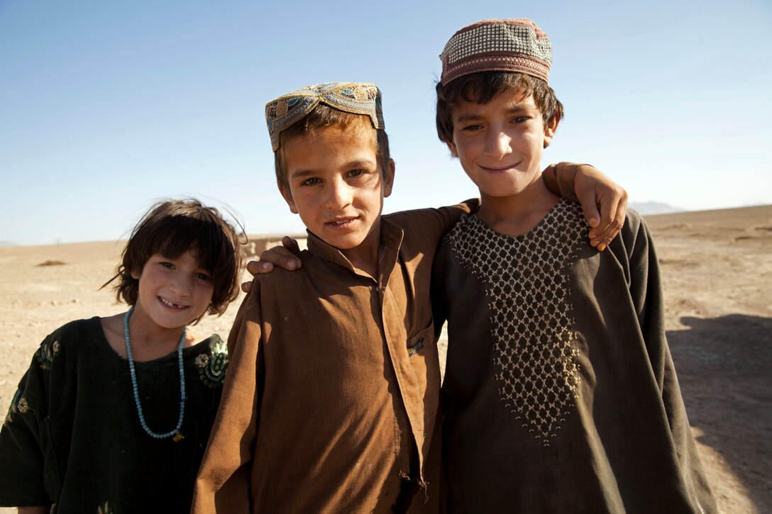 Afghan children pose for a photograph while watching U.S. Marines and Georgian soldiers patrol in Mohammad Abad village in Helmand province, Afghanistan, July 23, 2013.