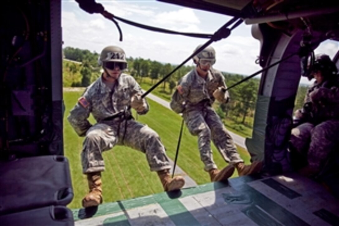 Army Cadets Timothy Dudley, left, and Nicholas Calderon get into position to rappel out of a UH-60 Black Hawk helicopter during the last phase of an air assault course on Fort Benning, Ga., July 23, 2013. 