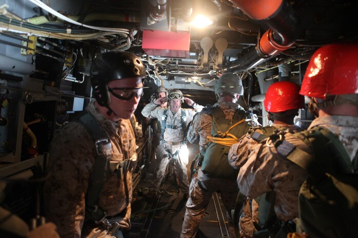 Marines prepare themselves as they stand by to jump out of the back of an MV-22B Osprey, July 25. 