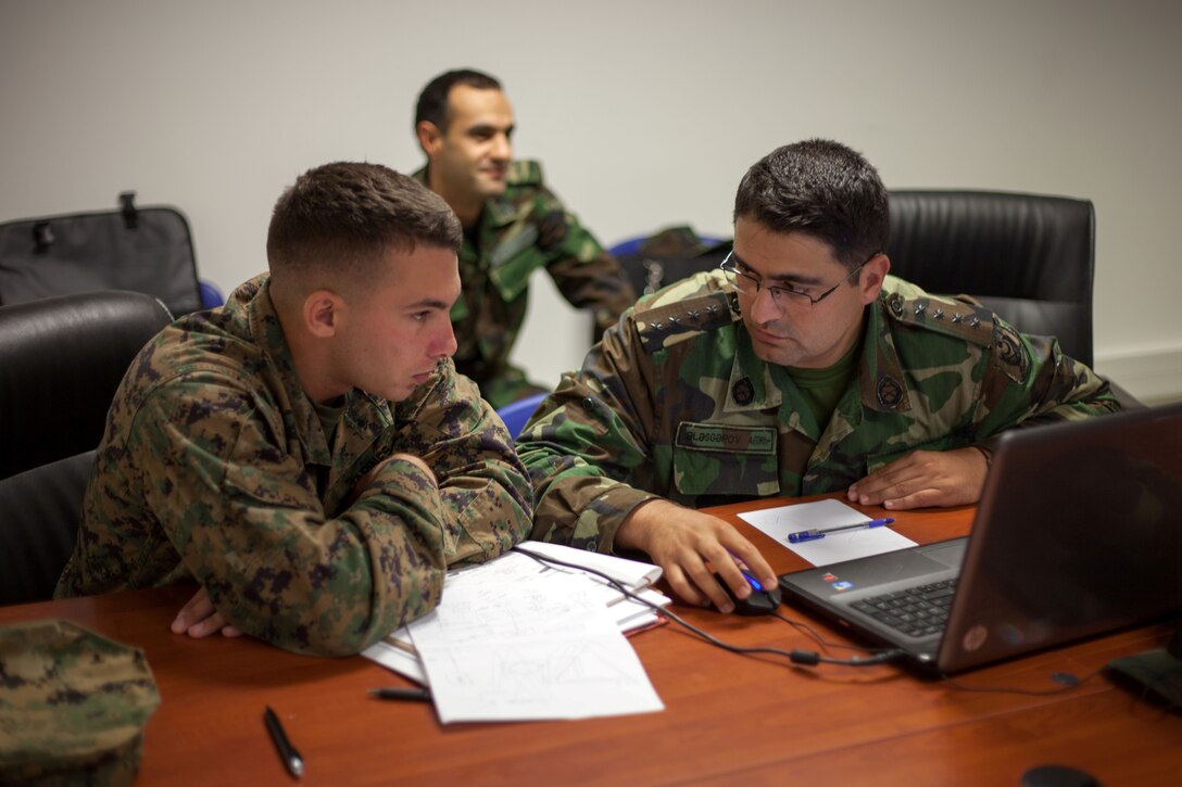 U.S. Marine Corps 1st Lt. Julian D’Orsaneo (left), communications officer for Black Sea Rotational Force 13, discusses tactical employment of communications assets with his counterpart from Azerbaijan’s Operational Capabilities Concept battalion during a bilateral staff planning session in Novo Selo Training Area, Bulgaria, July 21, 2013. BSRF-13 focuses on stability, counter-insurgency, and peacekeeping operations, in order to build partner-nation capacity, enhance interoperability between countries and increase overall effectiveness of participating military forces. 