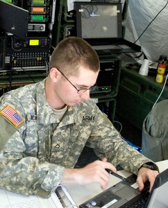 Pfc. Michael Becker, a chemical, biological, radiological, nuclear (CBRN) specialist of the 230th Signal Company Tennessee Army National Guard, mans the Joint Incident Site Communications Capabilities (JISCC) main desk. The 230th has set up the JISCC in support of the Vigilant Guard exercise at the Mid-South Support Center, Millington. Becker, a Clarksville, Tenn. resident, keeps a visitors log, and answers the phone while helping servicemembers use the internet, or telephones in the JISCC.