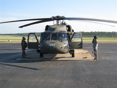 Sgt. Dewayne Phelps, left and Sgt. 1st. Class Mike Gunnels (right), both of Alexandria, stand as safety during pre-flight checks July 13 at Esler Airfield in Pineville. Two Louisiana National Guard UH-60 Blackhawk helicopters, 10 personnel (two crews and a maintenance team), prepare to leave from Esler Airfield in Pineville for California to support the California National Guard with fire fighting efforts.