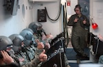 Active duty Senior Airman Rachel Cole makes a last minute breathing apparatus check on New York and Virginia National Guardsmen before sealing the oxygen chamber during high-altitude training at Andrews Air Force Base, Md. On Feb. 25.