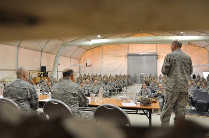 Gen. Craig McKinley, chief of the National Guard Bureau, Maj. Gen. Emmett Titshaw Jr., assistant to Chief of Staff of the U.S. Air Force, and the Guard Bureau's Command Sgt. Maj. David Hudson talk with Army and Air National Guardmembers at Baghdad International Airport, Iraq, March 1 during a town hall meeting. McKinley is traveling across the theatre of operations this week to hear first hand the thoughts and concerns of citizen-Soldiers and Airmen serving in Operation Iraqi Freedom and Operation Enduring Freedom.