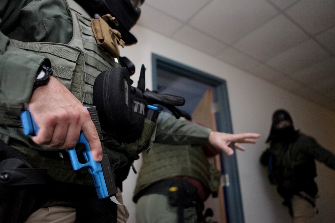 Marine Corps police officers with the Special Reaction Team perform room-clearing operations alongside the U.S. Marshals Gulf Coast Regional Fugitive Task Force during a training exercise at the Marine Corps Support Facility, July 2. This is one of multiple joint-training evolutions in which the SRT has honed their skills as a fully-functional force capable of addressing any high-risk situation that occurs at MARCORSPTFAC. (U.S. Marine Corps photo by Cpl. John M. McCall)