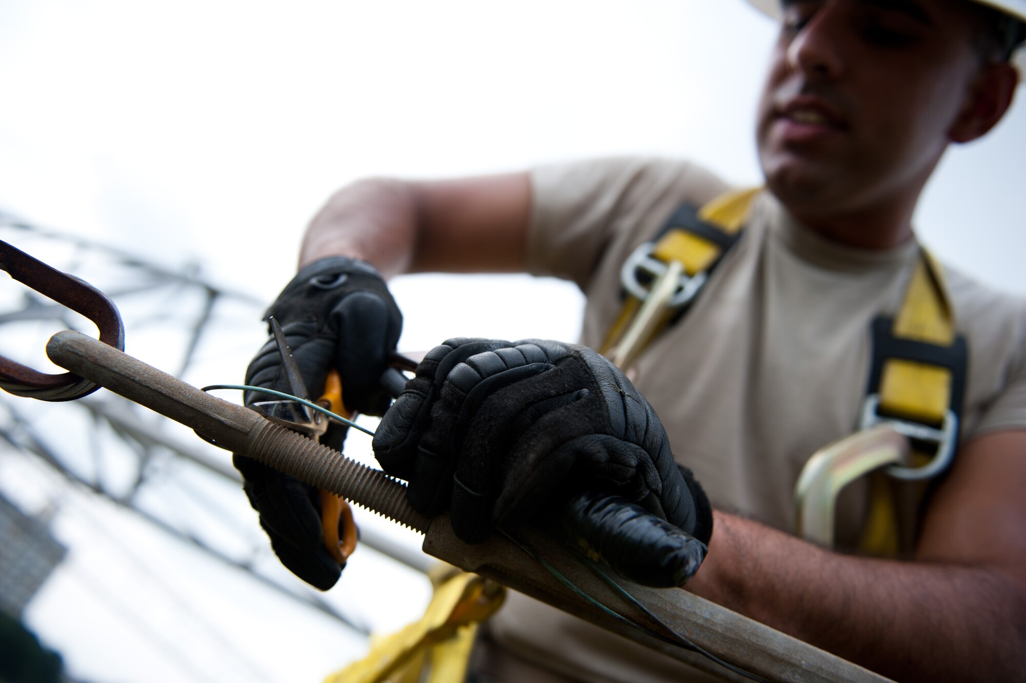 Airman 1st Class David Herrera, 374th Communications Squadron cable and antenna maintenance technician, cuts a safety cord before loosening a bolt on a rotatable log periodic antenna July 26, 2013, at the Tokorozawa Communication Site, Japan. Loosening the bolt removed tension built between two antenna arms and allowed Herrera and his team to more easily replace support bridges used between antenna segments. (U.S. Air Force photo by Senior Airman Cody H. Ramirez)
