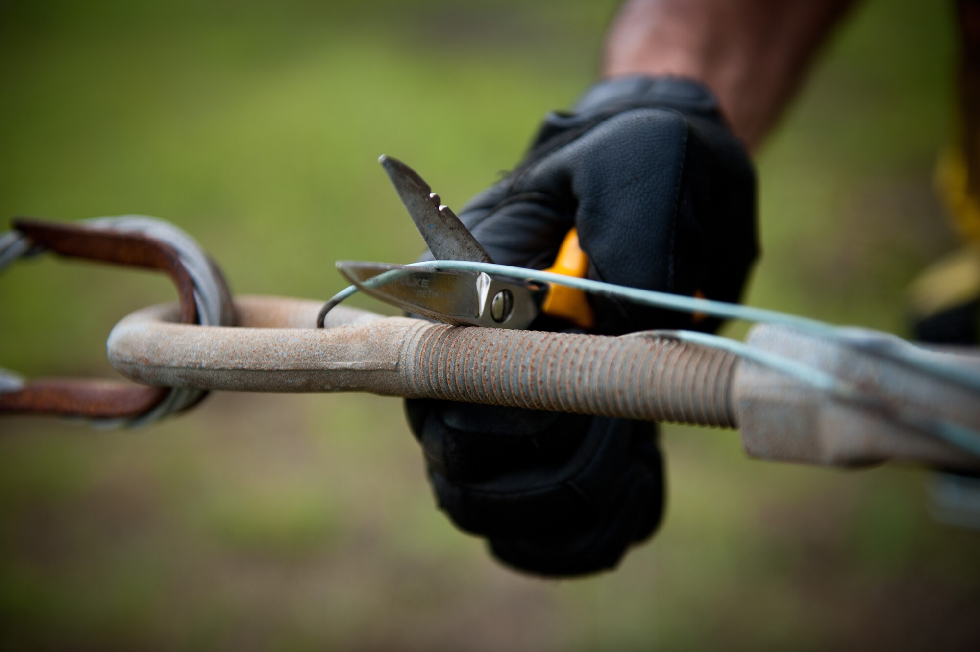 Airman 1st Class David Herrera, 374th Communications Squadron cable and antenna maintenance technician, cuts a safety cord before loosening a bolt on a rotatable log periodic antenna July 26, 2013, at the Tokorozawa Communication Site, Japan. Loosening the bolt removed tension built between two antenna arms and allowed Herrera and his team to more easily replace support bridges used between antenna segments. (U.S. Air Force photo by Senior Airman Cody H. Ramirez)